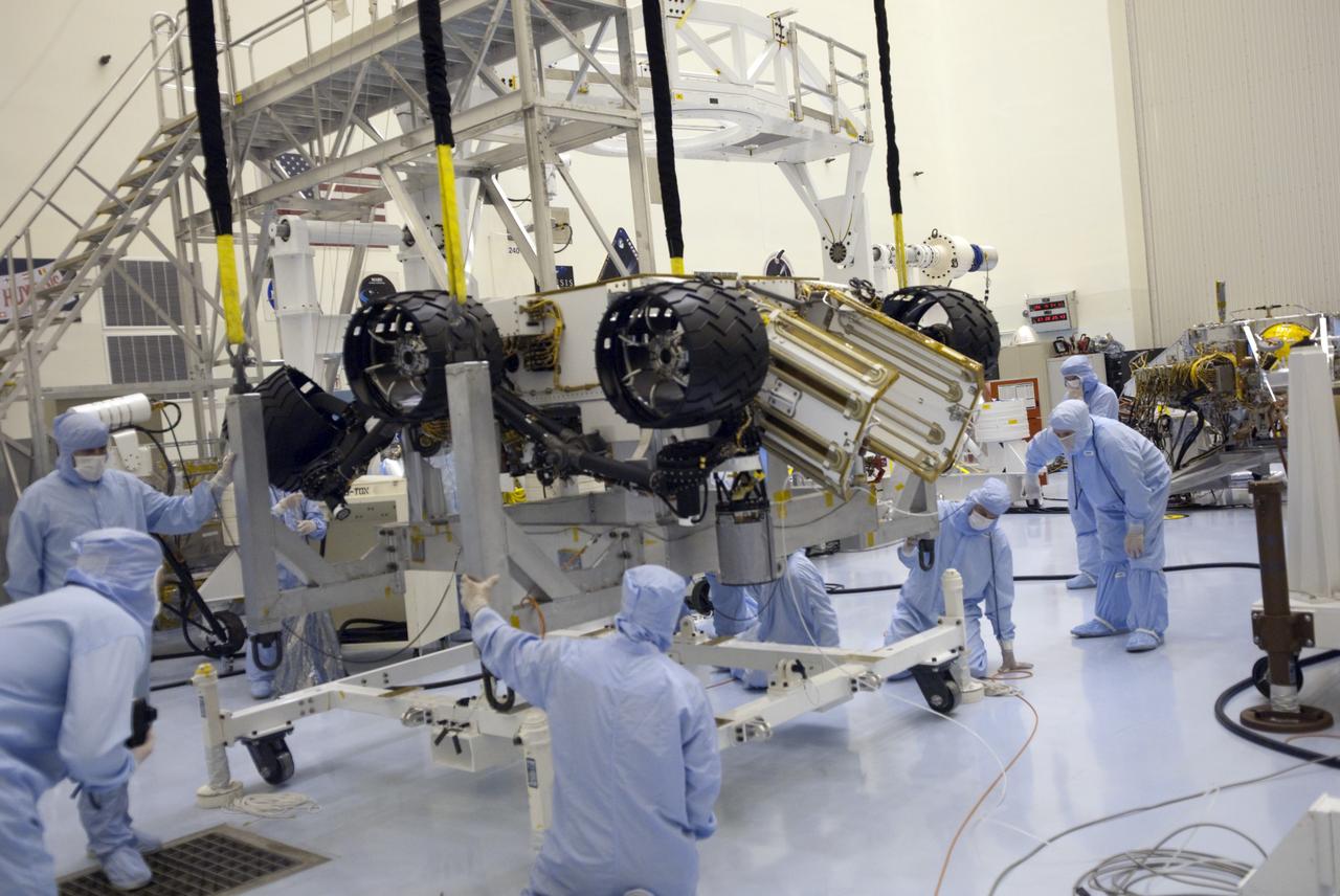 CAPE CANAVERAL, Fla. -- Technicians, using an overhead crane in the Payload Hazardous Servicing Facility at NASA's Kennedy Space Center in Florida, lower NASA's Mars Science Laboratory (MSL) rover, known as Curiosity, onto a rolling work stand for its move to a rotation fixture for testing. A United Launch Alliance Atlas V-541 configuration will be used to loft MSL into space. Curiosity’s 10 science instruments are designed to search for evidence on whether Mars has had environments favorable to microbial life, including chemical ingredients for life. The unique rover will use a laser to look inside rocks and release its gasses so that the rover’s spectrometer can analyze and send the data back to Earth. MSL is scheduled to launch from Cape Canaveral Air Force Station in Florida Nov. 25 with a window extending to Dec. 18 and arrival at Mars Aug. 2012. For more information, visit http://www.nasa.gov/msl. Photo credit: NASA/Jim Grossmann