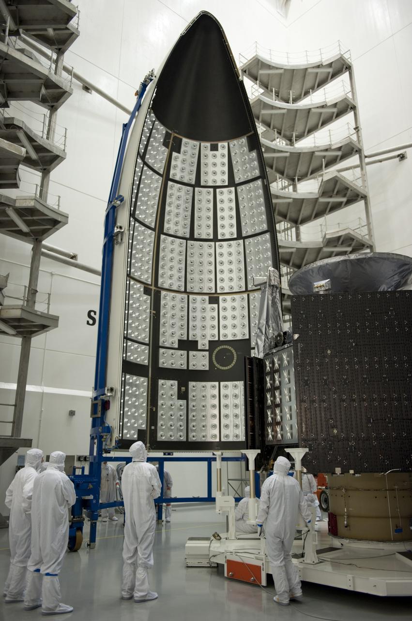 CAPE CANAVERAL, Fla. -- In the Astrotech payload processing facility near Kennedy Space Center in Florida, half of the Atlas payload fairing is moved toward the Juno spacecraft during work to enclose the spacecraft for launch.    The fairing will protect the spacecraft from the impact of aerodynamic pressure and heating during ascent and will be jettisoned once the spacecraft is outside the Earth's atmosphere. Juno is scheduled to launch aboard a United Launch Alliance Atlas V rocket from Cape Canaveral, Fla., Aug. 5.The solar-powered spacecraft will orbit Jupiter's poles 33 times to find out more about the gas giant's origins, structure, atmosphere and magnetosphere and investigate the existence of a solid planetary core. For more information, visit www.nasa.gov/juno. Photo credit: NASA/Kim Shiflett