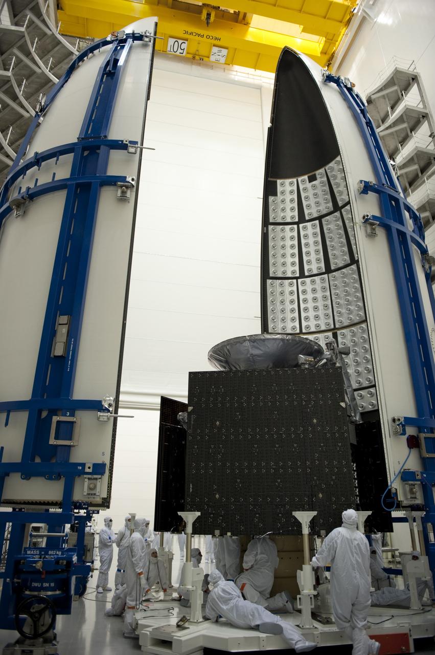 CAPE CANAVERAL, Fla. -- In the Astrotech payload processing facility near Kennedy Space Center in Florida, twin sections of the Atlas payload fairing are moved closer to the Juno spacecraft during work to enclose the spacecraft for launch.    The fairing will protect the spacecraft from the impact of aerodynamic pressure and heating during ascent and will be jettisoned once the spacecraft is outside the Earth's atmosphere. Juno is scheduled to launch aboard a United Launch Alliance Atlas V rocket from Cape Canaveral, Fla., Aug. 5.The solar-powered spacecraft will orbit Jupiter's poles 33 times to find out more about the gas giant's origins, structure, atmosphere and magnetosphere and investigate the existence of a solid planetary core. For more information, visit www.nasa.gov/juno. Photo credit: NASA/Kim Shiflett