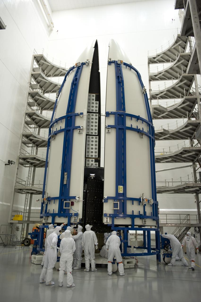 CAPE CANAVERAL, Fla. -- In the Astrotech payload processing facility near Kennedy Space Center in Florida, the Atlas payload fairing nearly obscures the Juno spacecraft from view during work to enclose the spacecraft for launch.    The fairing will protect the spacecraft from the impact of aerodynamic pressure and heating during ascent and will be jettisoned once the spacecraft is outside the Earth's atmosphere. Juno is scheduled to launch aboard a United Launch Alliance Atlas V rocket from Cape Canaveral, Fla., Aug. 5.The solar-powered spacecraft will orbit Jupiter's poles 33 times to find out more about the gas giant's origins, structure, atmosphere and magnetosphere and investigate the existence of a solid planetary core. For more information, visit www.nasa.gov/juno. Photo credit: NASA/Kim Shiflett