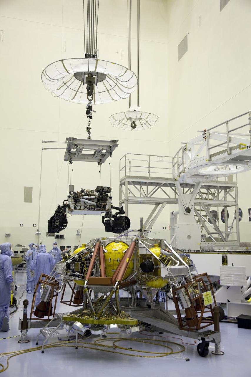Cape Canaveral, Fla. -- Technicians, at the Payload Hazardous Servicing Facility at NASA's Kennedy Space Center in Florida, use an overhead crane to move NASA's Mars Science Laboratory (MSL) rover, known as Curiosity, to the high bay floor where the instrument mast and science boom will undergo deployment testing. Also visible in the image is the rocket-powered descent stage (foreground).            A United Launch Alliance Atlas V-541 configuration will be used to loft MSL into space. Curiosity’s 10 science instruments are designed to search for evidence on whether Mars has had environments favorable to microbial life, including chemical ingredients for life.  The unique rover will use a laser to look inside rocks and release its gasses so that the rover’s spectrometer can analyze and send the data back to Earth. MSL is scheduled to launch from Cape Canaveral Air Force Station in Florida Nov. 25 with a window extending to Dec. 18 and arrival at Mars Aug. 2012. For more information, visit http://www.nasa.gov/msl. Photo credit: NASA/Frankie Martin