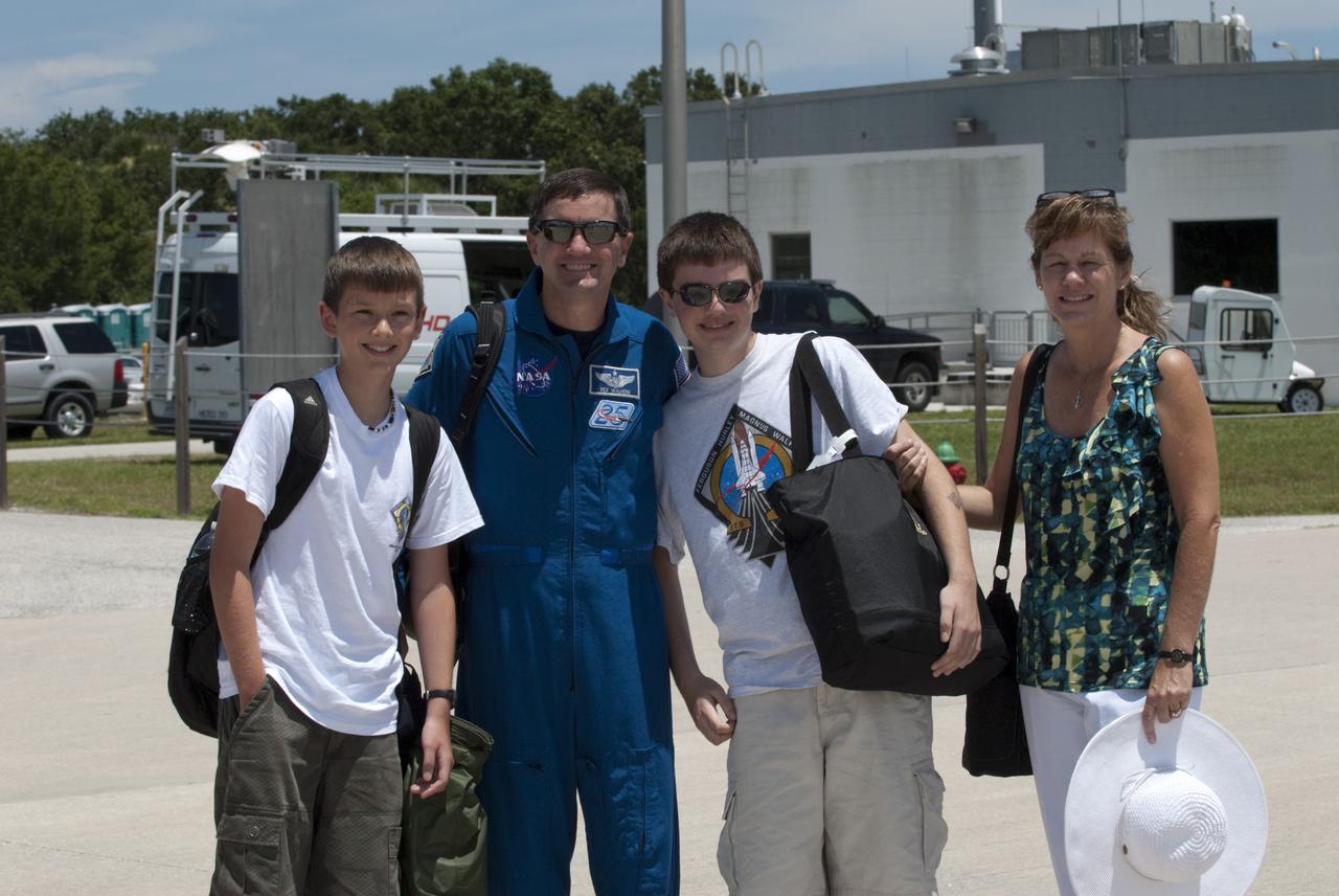 CAPE CANAVERAL, Fla. -- The STS-135 astronauts prepare to depart NASA's Kennedy Space Center in Florida to return to NASA's Johnson Space Center in Houston. Space shuttle Atlantis and its crew touched down on Kennedy's Shuttle Landing Facility runway 5:57 a.m., July 21, 2011, bringing a close to 30 years of space shuttle missions. Here, STS-135 Mission Specialist Rex Walheim and his family stop for a photo before boarding a Gulfstream III jet that will take them back home. Securing the space shuttle fleet's place in history, Atlantis marked the 26th nighttime landing of the Space Shuttle Program and the 78th landing at Kennedy. Atlantis and its crew delivered to the International Space Station the Raffaello multi-purpose logistics module packed with more than 9,400 pounds of spare parts, equipment and supplies that will sustain station operations for the next year. STS-135 was the 33rd and final flight for Atlantis and the final mission of the Space Shuttle Program. For more information, visit www.nasa.gov/mission_pages/shuttle/shuttlemissions/sts135/index.html. Photo credit: NASA/Kim Shiflett