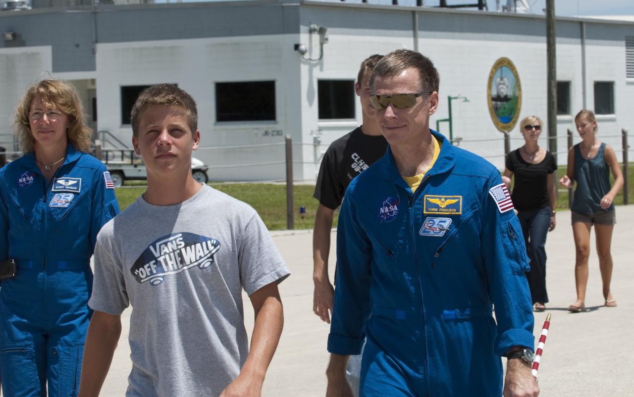 CAPE CANAVERAL, Fla. -- The STS-135 astronauts prepare to depart NASA's Kennedy Space Center in Florida to return to NASA's Johnson Space Center in Houston. Space shuttle Atlantis and its crew touched down on Kennedy's Shuttle Landing Facility runway 5:57 a.m., July 21, 2011, bringing a close to 30 years of space shuttle missions. Here, STS-135 Commander Chris Ferguson and his son walk toward a Gulfstream III jet that will take them back home. STS-135 Mission Specialist Sandy Magnus follows close behind them, at left. Securing the space shuttle fleet's place in history, Atlantis marked the 26th nighttime landing of the Space Shuttle Program and the 78th landing at Kennedy. Atlantis and its crew delivered to the International Space Station the Raffaello multi-purpose logistics module packed with more than 9,400 pounds of spare parts, equipment and supplies that will sustain station operations for the next year. STS-135 was the 33rd and final flight for Atlantis and the final mission of the Space Shuttle Program. For more information, visit www.nasa.gov/mission_pages/shuttle/shuttlemissions/sts135/index.html. Photo credit: NASA/Kim Shiflett