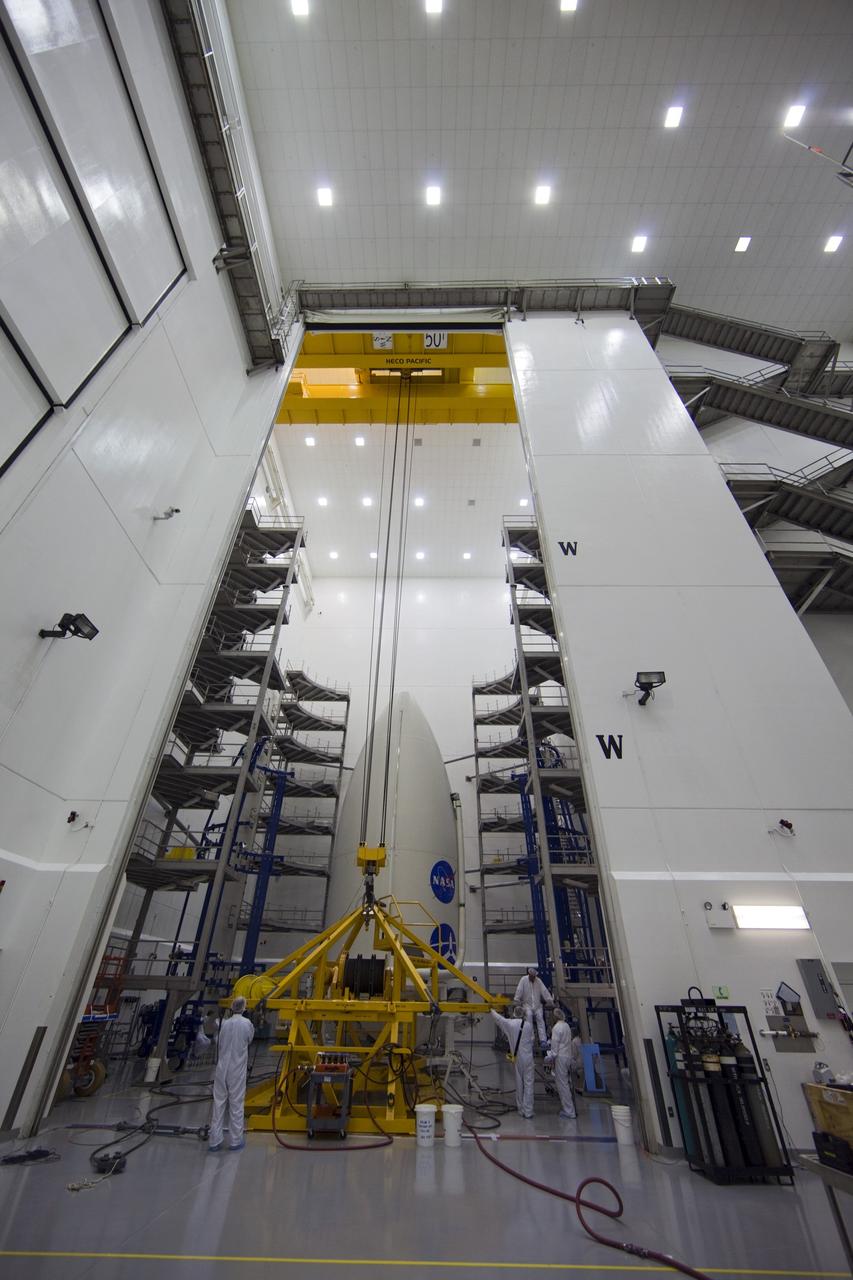 CAPE CANAVERAL, Fla. -- In the Astrotech payload processing facility near Kennedy Space Center in Florida, spacecraft technicians prepare to lift the Juno spacecraft, enclosed in an Atlas payload fairing, onto a transporter for its trip to Space Launch Complex 41.    The fairing will protect the spacecraft from the impact of aerodynamic pressure and heating during ascent and will be jettisoned once the spacecraft is outside the Earth's atmosphere. Juno is scheduled to launch aboard a United Launch Alliance Atlas V rocket from Cape Canaveral, Fla., Aug. 5.The solar-powered spacecraft will orbit Jupiter's poles 33 times to find out more about the gas giant's origins, structure, atmosphere and magnetosphere and investigate the existence of a solid planetary core. For more information, visit www.nasa.gov/juno. Photo credit: NASA/Frank Michaux