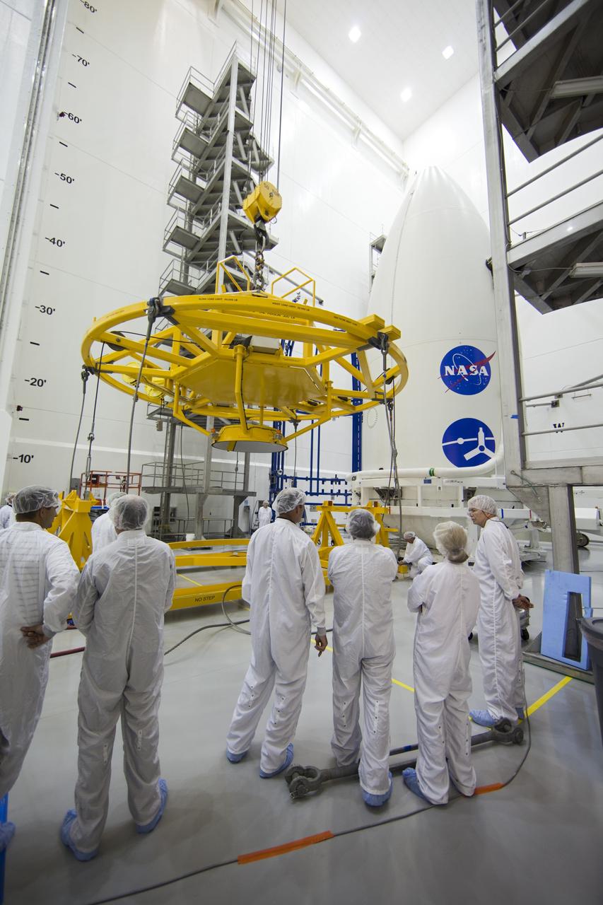 CAPE CANAVERAL, Fla. -- In the Astrotech payload processing facility near Kennedy Space Center in Florida, spacecraft technicians move a lifting device toward the Juno spacecraft, enclosed in an Atlas payload fairing, during operations to lift the spacecraft onto a transporter for its trip to Space Launch Complex 41.    The fairing will protect the spacecraft from the impact of aerodynamic pressure and heating during ascent and will be jettisoned once the spacecraft is outside the Earth's atmosphere. Juno is scheduled to launch aboard a United Launch Alliance Atlas V rocket from Cape Canaveral, Fla., Aug. 5.The solar-powered spacecraft will orbit Jupiter's poles 33 times to find out more about the gas giant's origins, structure, atmosphere and magnetosphere and investigate the existence of a solid planetary core. For more information, visit www.nasa.gov/juno. Photo credit: NASA/Frank Michaux