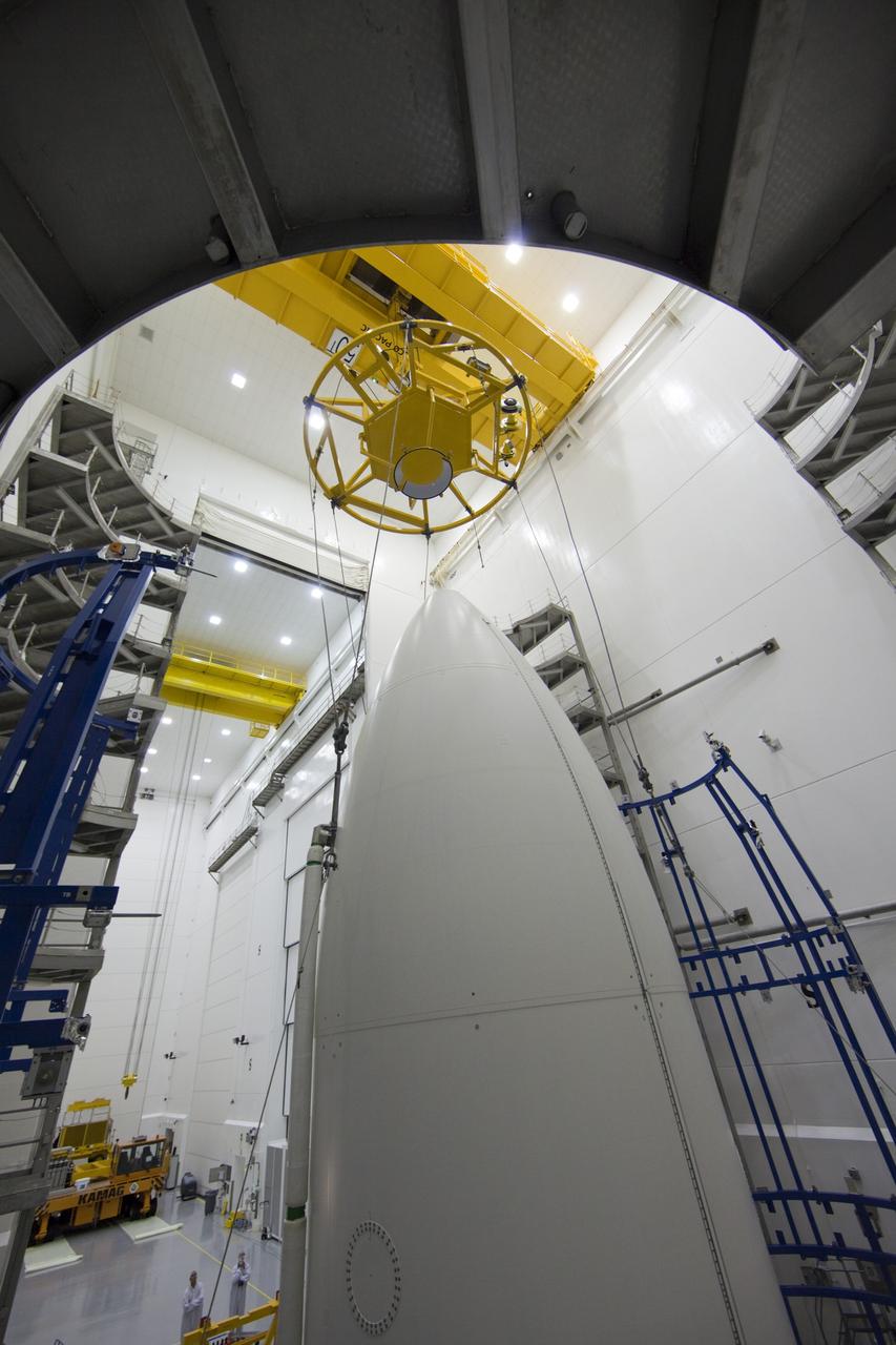 CAPE CANAVERAL, Fla. -- In the Astrotech payload processing facility near Kennedy Space Center in Florida, a lifting device is positioned over the Atlas payload fairing enclosing the Juno spacecraft during operations to lift the spacecraft onto a transporter for its trip to Space Launch Complex 41. The fairing will protect the spacecraft from the impact of aerodynamic pressure and heating during ascent and will be jettisoned once the spacecraft is outside the Earth's atmosphere. Juno is scheduled to launch aboard a United Launch Alliance Atlas V rocket from Cape Canaveral, Fla., Aug. 5.The solar-powered spacecraft will orbit Jupiter's poles 33 times to find out more about the gas giant's origins, structure, atmosphere and magnetosphere and investigate the existence of a solid planetary core. For more information, visit www.nasa.gov/juno. Photo credit: NASA/Frank Michaux