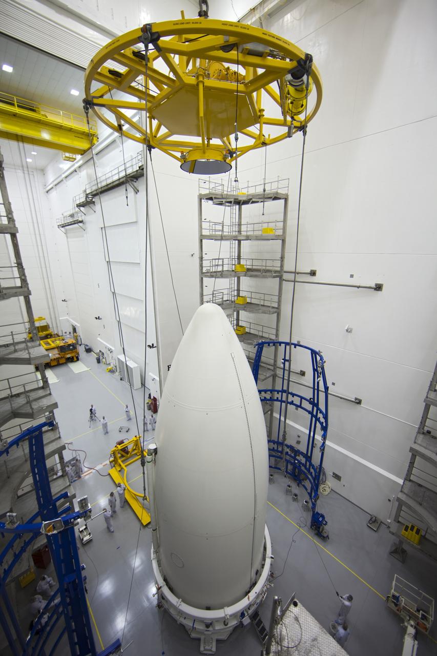 CAPE CANAVERAL, Fla. -- In the Astrotech payload processing facility near Kennedy Space Center in Florida, a lifting device is lowered toward the Atlas payload fairing enclosing the Juno spacecraft during operations to lift the spacecraft onto a transporter for its trip to Space Launch Complex 41.    The fairing will protect the spacecraft from the impact of aerodynamic pressure and heating during ascent and will be jettisoned once the spacecraft is outside the Earth's atmosphere. Juno is scheduled to launch aboard a United Launch Alliance Atlas V rocket from Cape Canaveral, Fla., Aug. 5.The solar-powered spacecraft will orbit Jupiter's poles 33 times to find out more about the gas giant's origins, structure, atmosphere and magnetosphere and investigate the existence of a solid planetary core. For more information, visit www.nasa.gov/juno. Photo credit: NASA/Frank Michaux