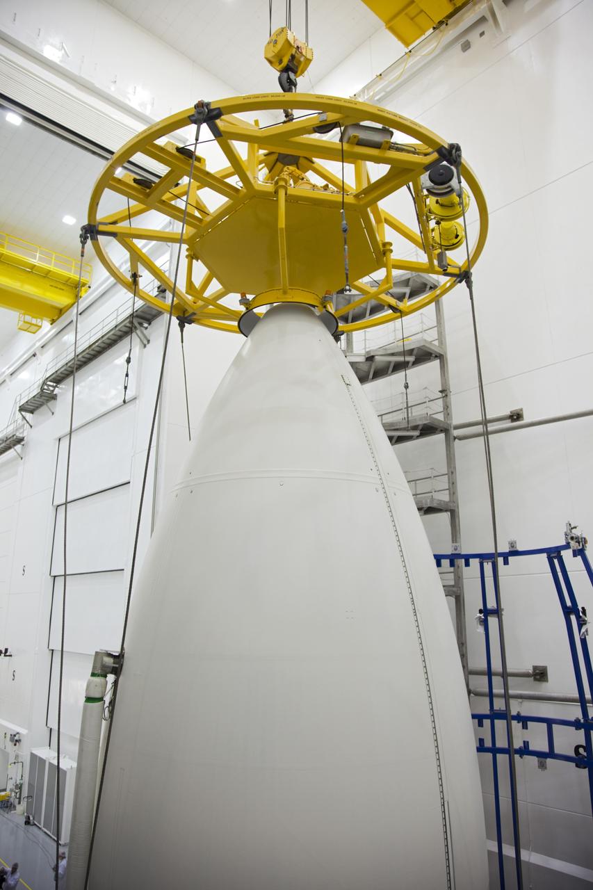 CAPE CANAVERAL, Fla. -- In the Astrotech payload processing facility near Kennedy Space Center in Florida, a lifting device is lowered onto the nose of the Atlas payload fairing enclosing the Juno spacecraft during operations to lift the spacecraft onto a transporter for its trip to Space Launch Complex 41.    The fairing will protect the spacecraft from the impact of aerodynamic pressure and heating during ascent and will be jettisoned once the spacecraft is outside the Earth's atmosphere. Juno is scheduled to launch aboard a United Launch Alliance Atlas V rocket from Cape Canaveral, Fla., Aug. 5.The solar-powered spacecraft will orbit Jupiter's poles 33 times to find out more about the gas giant's origins, structure, atmosphere and magnetosphere and investigate the existence of a solid planetary core. For more information, visit www.nasa.gov/juno. Photo credit: NASA/Frank Michaux