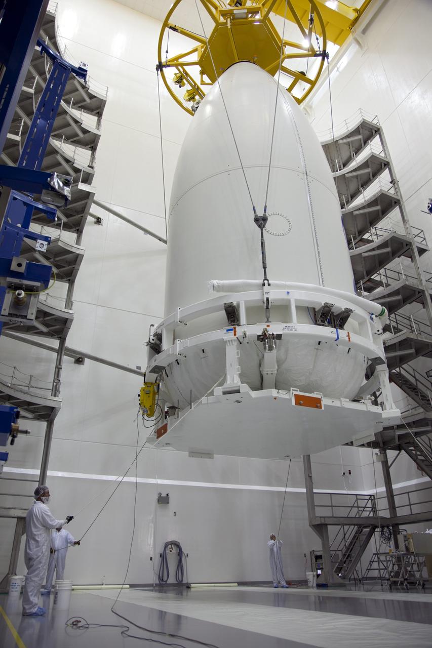 CAPE CANAVERAL, Fla. -- In the Astrotech payload processing facility near Kennedy Space Center in Florida, a lifting device raises the Atlas payload fairing enclosing the Juno spacecraft from the clean-room floor during operations to lift the spacecraft onto a transporter for its trip to Space Launch Complex 41.    The fairing will protect the spacecraft from the impact of aerodynamic pressure and heating during ascent and will be jettisoned once the spacecraft is outside the Earth's atmosphere. Juno is scheduled to launch aboard a United Launch Alliance Atlas V rocket from Cape Canaveral, Fla., Aug. 5.The solar-powered spacecraft will orbit Jupiter's poles 33 times to find out more about the gas giant's origins, structure, atmosphere and magnetosphere and investigate the existence of a solid planetary core. For more information, visit www.nasa.gov/juno. Photo credit: NASA/Frank Michaux