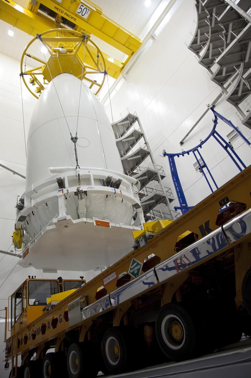 CAPE CANAVERAL, Fla. -- In the Astrotech payload processing facility near Kennedy Space Center in Florida, a lifting device transfers the Atlas payload fairing enclosing the Juno spacecraft over a transporter during operations to move the spacecraft to Space Launch Complex 41.    The fairing will protect the spacecraft from the impact of aerodynamic pressure and heating during ascent and will be jettisoned once the spacecraft is outside the Earth's atmosphere. Juno is scheduled to launch aboard a United Launch Alliance Atlas V rocket from Cape Canaveral, Fla., Aug. 5.The solar-powered spacecraft will orbit Jupiter's poles 33 times to find out more about the gas giant's origins, structure, atmosphere and magnetosphere and investigate the existence of a solid planetary core. For more information, visit www.nasa.gov/juno. Photo credit: NASA/Frank Michaux