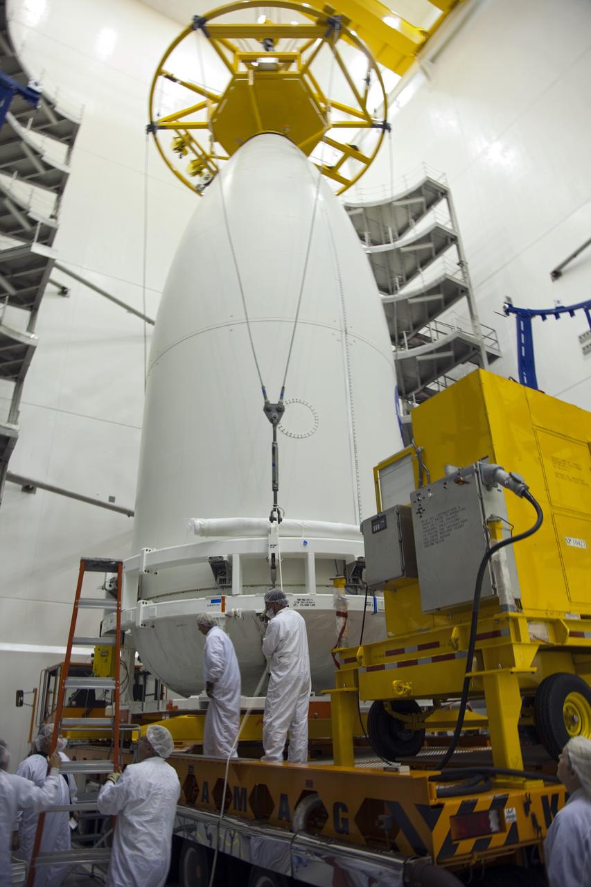 CAPE CANAVERAL, Fla. -- In the Astrotech payload processing facility near Kennedy Space Center in Florida, spacecraft technicians secure the Atlas payload fairing enclosing the Juno spacecraft on a transporter during operations to move the spacecraft to Space Launch Complex 41.    The fairing will protect the spacecraft from the impact of aerodynamic pressure and heating during ascent and will be jettisoned once the spacecraft is outside the Earth's atmosphere. Juno is scheduled to launch aboard a United Launch Alliance Atlas V rocket from Cape Canaveral, Fla., Aug. 5.The solar-powered spacecraft will orbit Jupiter's poles 33 times to find out more about the gas giant's origins, structure, atmosphere and magnetosphere and investigate the existence of a solid planetary core. For more information, visit www.nasa.gov/juno. Photo credit: NASA/Frank Michaux