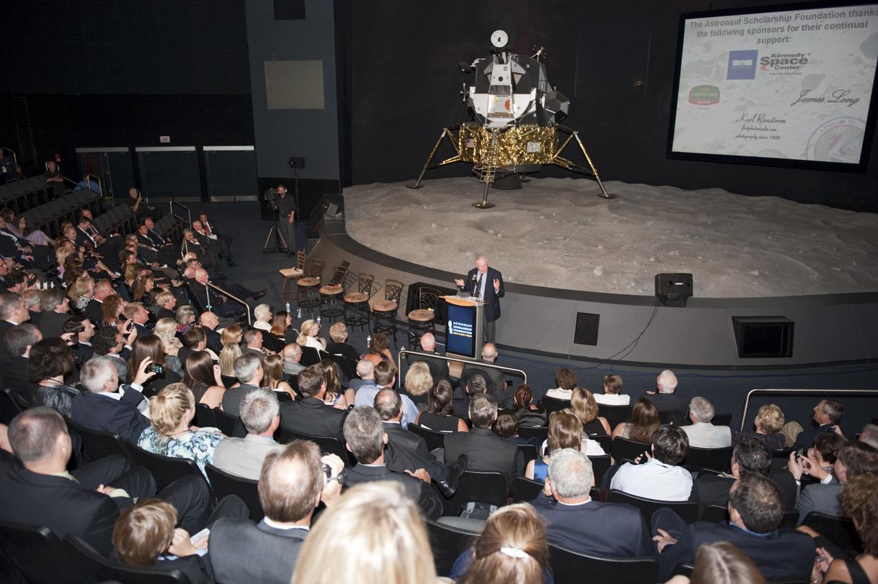 CAPE CANAVERAL, Fla. -- The Apollo/Saturn V Center at NASA's Kennedy Space Center in Florida hosted a celebration on the 40th anniversary of NASA's Apollo 15 mission. Apollo 15 Commander Dave Scott and Command Module Pilot Al Worden and an elite gathering of Apollo-era astronauts were on hand for the event and panel discussion. Here, Apollo 11 Commander Neil Armstrong speaks to the invited guests. In the background is a model of the Lunar Module, part of the lander portion of the Apollo spacecraft. Worden circled the moon while Scott and the late Jim Irwin, the Lunar Module commander, made history when they became the first humans to drive a vehicle on the surface of the moon. They also provided extensive descriptions and photographic documentation of geologic features in the vicinity of the Hadley Rille landing site during their three days on the lunar surface. Photo credit: NASA/Kim Shiflett
