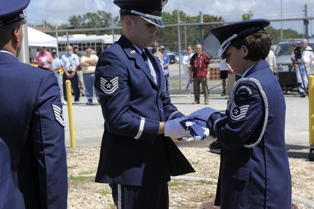 CAPE CANAVERAL, Fla. -- At the Merritt Island Launch Annex (MILA) Spaceflight Tracking and Data Network Station at NASA's Kennedy Space Center in Florida, the Patrick Air Force Base Color Guard folds the U.S. flag for the last time at a closing ceremony recognizing the station's 45 years of service.    The station was originally established by NASA's Goddard Space Flight Center as one of 17 Space Flight Tracking and Data Network stations around the world. Commissioned for the Apollo Program, the first launch it supported was the Apollo/Saturn 203 test flight from Launch Complex 37 on July 5, 1966. It also provided orbital support for low earth-orbiting scientific satellites. In recent history, the station has been used almost exclusively for space shuttle launch and landing support. Following the final launch and landing of the Space Shuttle Program in July 2011, the MILA station is officially decommissioned. For more information, visit http://www.nasa.gov/centers/kennedy/pdf/167424main_MILA-08C.pdf. Photo credit: NASA/Kim Shiflett