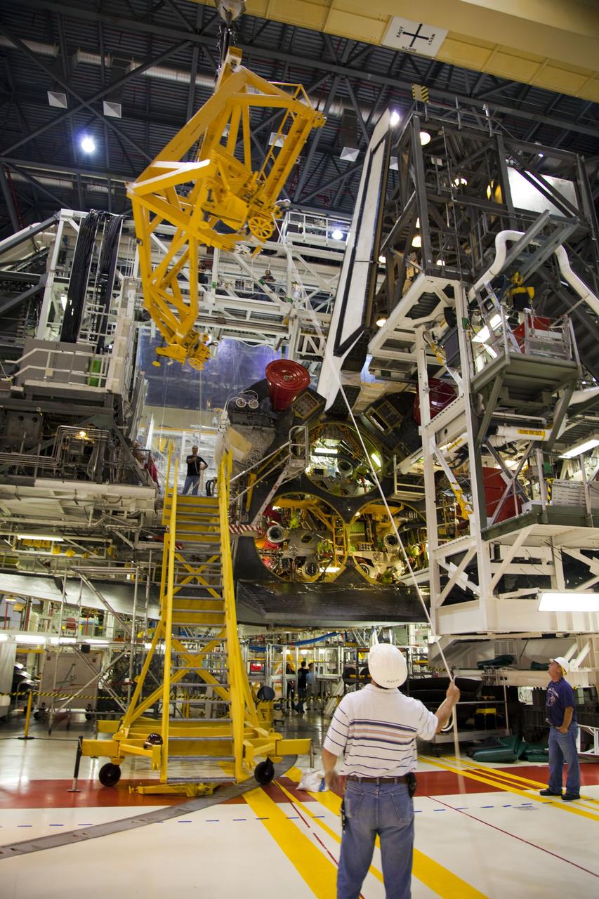 CAPE CANAVERAL, Fla. -- In Orbiter Processing Facility-1 at NASA’s Kennedy Space Center in Florida, workers monitor the progress as an overhead crane is moved into place to begin the process of removing shuttle Endeavour’s orbital maneuvering system, or OMS, pods.The work is part of Endeavour’s transition and retirement processing. The spacecraft is being prepared for public display at the California Science Center in Los Angeles. Endeavour flew 25 missions, spent 299 days in space, orbited Earth 4,671 times and traveled 122, 883, 151 miles over the course of its 19-year career. Endeavour’s STS-134 and final mission was completed after landing on June 1, 2011. Photo credit: Frank Michaux