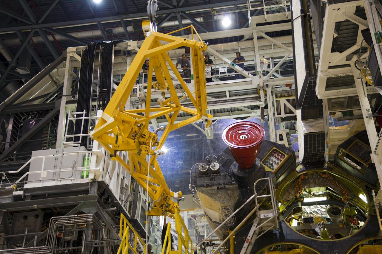 CAPE CANAVERAL, Fla. -- In Orbiter Processing Facility-1 at NASA’s Kennedy Space Center in Florida, workers monitor the progress as an overhead crane is moved into place to begin the process of removing shuttle Endeavour’s left-hand orbital maneuvering system, or OMS, pod. The work is part of Endeavour’s transition and retirement processing. The spacecraft is being prepared for public display at the California Science Center in Los Angeles. Endeavour flew 25 missions, spent 299 days in space, orbited Earth 4,671 times and traveled 122, 883, 151 miles over the course of its 19-year career. Endeavour’s STS-134 and final mission was completed after landing on June 1, 2011. Photo credit: Frank Michaux