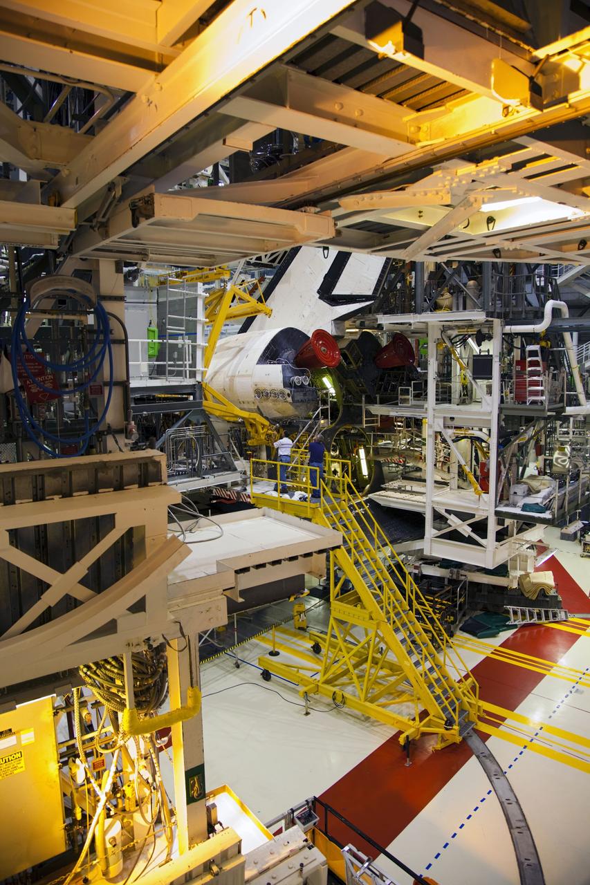 CAPE CANAVERAL, Fla. -- In Orbiter Processing Facility-1 at NASA’s Kennedy Space Center in Florida, workers monitor the progress as an overhead crane is moved into place around shuttle Endeavour’s left-hand orbital maneuvering system, or OMS, pod, to begin removal of the component. The work is part of Endeavour’s transition and retirement processing. The spacecraft is being prepared for public display at the California Science Center in Los Angeles. Endeavour flew 25 missions, spent 299 days in space, orbited Earth 4,671 times and traveled 122, 883, 151 miles over the course of its 19-year career. Endeavour’s STS-134 and final mission was completed after landing on June 1, 2011. Photo credit: Frank Michaux