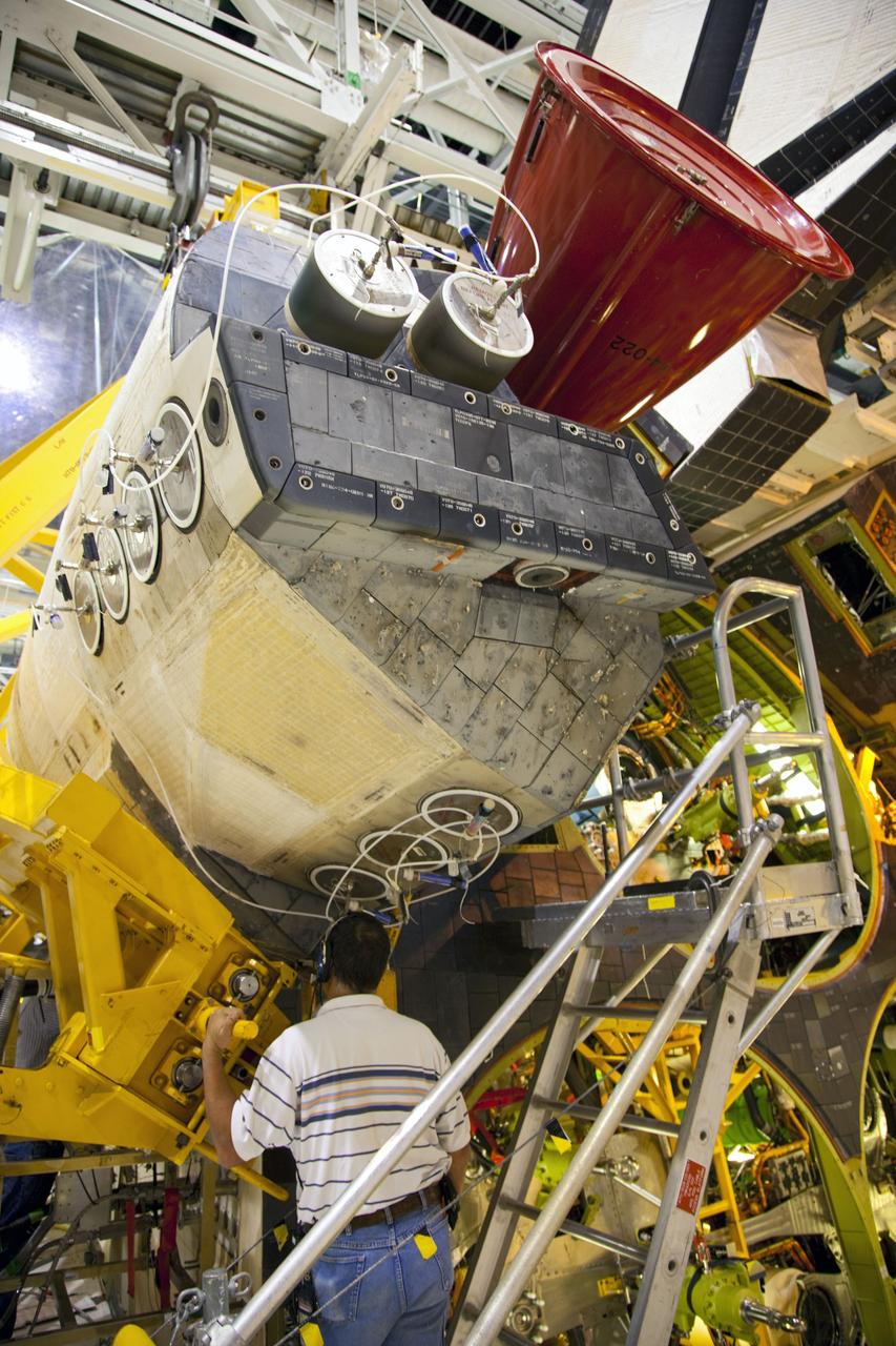 CAPE CANAVERAL, Fla. -- In Orbiter Processing Facility-1 at NASA’s Kennedy Space Center in Florida, a worker monitors the progress as an overhead crane is moved into place around shuttle Endeavour’s left-hand orbital maneuvering system, or OMS, pod, to begin removal of the component. The work is part of Endeavour’s transition and retirement processing. The spacecraft is being prepared for public display at the California Science Center in Los Angeles. Endeavour flew 25 missions, spent 299 days in space, orbited Earth 4,671 times and traveled 122, 883, 151 miles over the course of its 19-year career. Endeavour’s STS-134 and final mission was completed after landing on June 1, 2011. Photo credit: Frank Michaux
