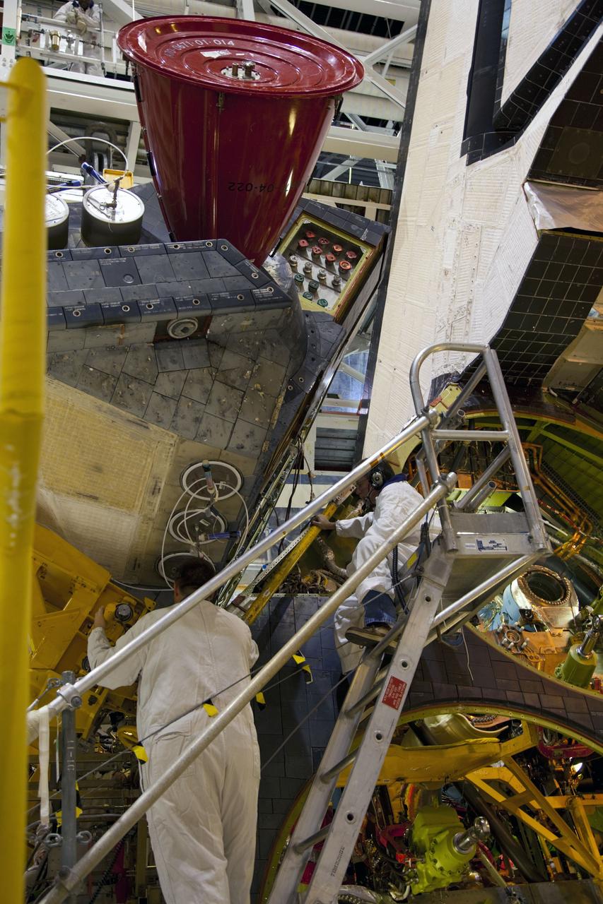 CAPE CANAVERAL, Fla. -- In Orbiter Processing Facility-1 at NASA’s Kennedy Space Center in Florida, technicians monitor the progress as an overhead crane removes shuttle Endeavour’s left-hand orbital maneuvering system, or OMS, pod. The work is part of Endeavour’s transition and retirement processing. The spacecraft is being prepared for public display at the California Science Center in Los Angeles. Endeavour flew 25 missions, spent 299 days in space, orbited Earth 4,671 times and traveled 122, 883, 151 miles over the course of its 19-year career. Endeavour’s STS-134 and final mission was completed after landing on June 1, 2011. Photo credit: Frank Michaux