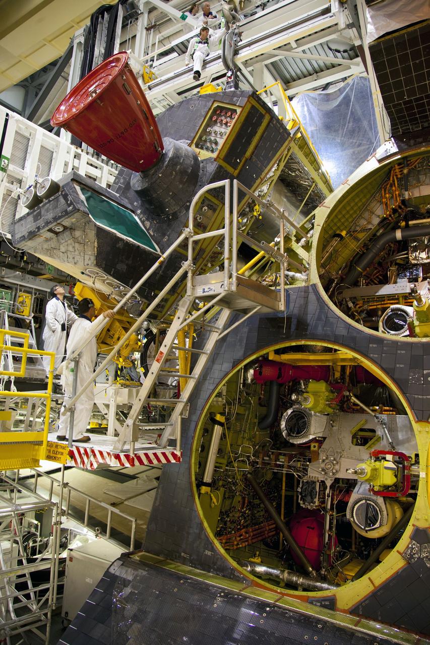 CAPE CANAVERAL, Fla. -- In Orbiter Processing Facility-1 at NASA’s Kennedy Space Center in Florida, technicians monitor the progress as an overhead crane removes shuttle Endeavour’s left-hand orbital maneuvering system, or OMS, pod. The work is part of Endeavour’s transition and retirement processing. The spacecraft is being prepared for public display at the California Science Center in Los Angeles. Endeavour flew 25 missions, spent 299 days in space, orbited Earth 4,671 times and traveled 122, 883, 151 miles over the course of its 19-year career. Endeavour’s STS-134 and final mission was completed after landing on June 1, 2011. Photo credit: Frank Michaux