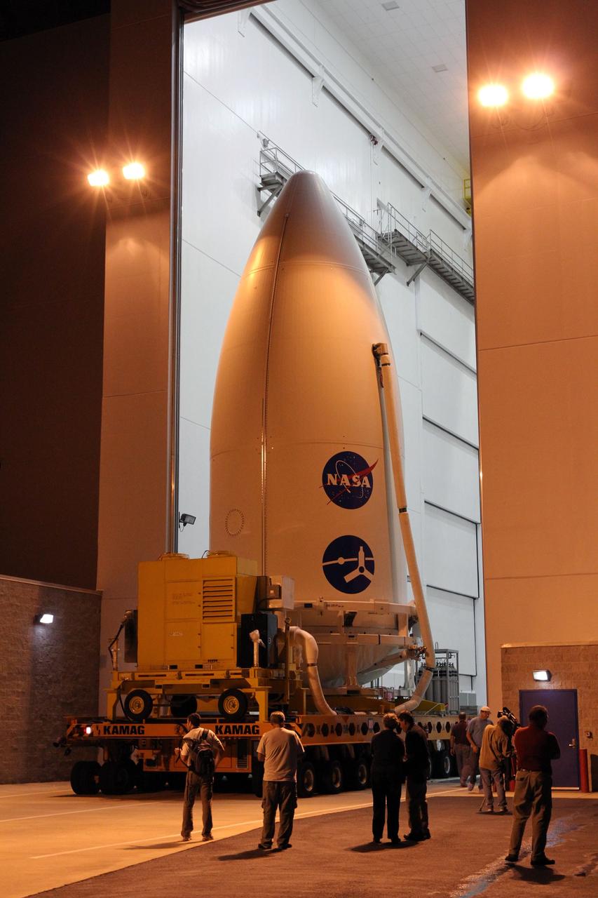 CAPE CANAVERAL, Fla. -- The Juno spacecraft, enclosed in an Atlas payload fairing, rolls out of the Astrotech Space Operations' payload processing facility in Titusville, Fla., for its trip to Space Launch Complex 41.    The fairing will protect the spacecraft from the impact of aerodynamic pressure and heating during ascent and will be jettisoned once the spacecraft is outside the Earth's atmosphere. Juno is scheduled to launch Aug. 5 aboard a United Launch Alliance Atlas V rocket from Cape Canaveral Air Force Station in Florida. The solar-powered spacecraft will orbit Jupiter's poles 33 times to find out more about the gas giant's origins, structure, atmosphere and magnetosphere and investigate the existence of a solid planetary core. For more information, visit www.nasa.gov/juno. Photo credit: NASA/Cory Huston
