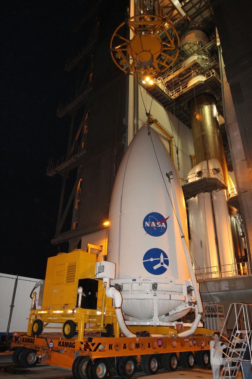 CAPE CANAVERAL, Fla. -- At Space Launch Complex 41, a crane is lowered toward the Juno spacecraft, enclosed in an Atlas payload fairing, to lift it on top of the Atlas rocket stacked in the Vertical Integration Facility.  The spacecraft was prepared for launch in the Astrotech Space Operations' payload processing facility in Titusville, Fla.    The fairing will protect the spacecraft from the impact of aerodynamic pressure and heating during ascent and will be jettisoned once the spacecraft is outside the Earth's atmosphere. Juno is scheduled to launch Aug. 5 aboard a United Launch Alliance Atlas V rocket from Cape Canaveral Air Force Station in Florida. The solar-powered spacecraft will orbit Jupiter's poles 33 times to find out more about the gas giant's origins, structure, atmosphere and magnetosphere and investigate the existence of a solid planetary core. For more information, visit www.nasa.gov/juno. Photo credit: NASA/Cory Huston