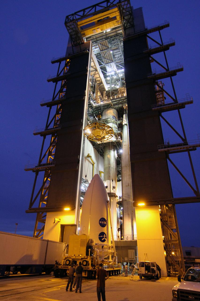 CAPE CANAVERAL, Fla. -- At Space Launch Complex 41, technicians monitor a crane as it is lowered toward the Juno spacecraft, enclosed in an Atlas payload fairing, for its lift to the top of the Atlas rocket stacked in the Vertical Integration Facility.  The spacecraft was prepared for launch in the Astrotech Space Operations' payload processing facility in Titusville, Fla.    The fairing will protect the spacecraft from the impact of aerodynamic pressure and heating during ascent and will be jettisoned once the spacecraft is outside the Earth's atmosphere. Juno is scheduled to launch Aug. 5 aboard a United Launch Alliance Atlas V rocket from Cape Canaveral Air Force Station in Florida. The solar-powered spacecraft will orbit Jupiter's poles 33 times to find out more about the gas giant's origins, structure, atmosphere and magnetosphere and investigate the existence of a solid planetary core. For more information, visit www.nasa.gov/juno. Photo credit: NASA/Cory Huston