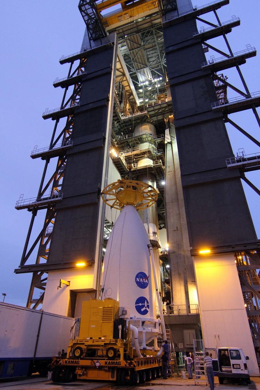 CAPE CANAVERAL, Fla. -- At Space Launch Complex 41, a crane is lowered over the nose of the Atlas payload fairing enclosing the Juno spacecraft in preparation for its lift to the top of the Atlas rocket stacked in the Vertical Integration Facility.  The spacecraft was prepared for launch in the Astrotech Space Operations' payload processing facility in Titusville, Fla.    The fairing will protect the spacecraft from the impact of aerodynamic pressure and heating during ascent and will be jettisoned once the spacecraft is outside the Earth's atmosphere. Juno is scheduled to launch Aug. 5 aboard a United Launch Alliance Atlas V rocket from Cape Canaveral Air Force Station in Florida. The solar-powered spacecraft will orbit Jupiter's poles 33 times to find out more about the gas giant's origins, structure, atmosphere and magnetosphere and investigate the existence of a solid planetary core. For more information, visit www.nasa.gov/juno. Photo credit: NASA/Cory Huston