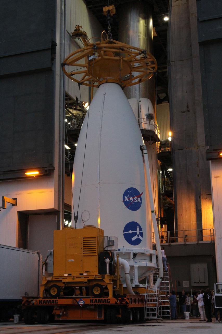 CAPE CANAVERAL, Fla. -- At Space Launch Complex 41, a crane comes to rest on the nose of the Atlas payload fairing enclosing the Juno spacecraft in preparation for its lift to the top of the Atlas rocket stacked in the Vertical Integration Facility.  The spacecraft was prepared for launch in the Astrotech Space Operations' payload processing facility in Titusville, Fla.    The fairing will protect the spacecraft from the impact of aerodynamic pressure and heating during ascent and will be jettisoned once the spacecraft is outside the Earth's atmosphere. Juno is scheduled to launch Aug. 5 aboard a United Launch Alliance Atlas V rocket from Cape Canaveral Air Force Station in Florida. The solar-powered spacecraft will orbit Jupiter's poles 33 times to find out more about the gas giant's origins, structure, atmosphere and magnetosphere and investigate the existence of a solid planetary core. For more information, visit www.nasa.gov/juno. Photo credit: NASA/Cory Huston