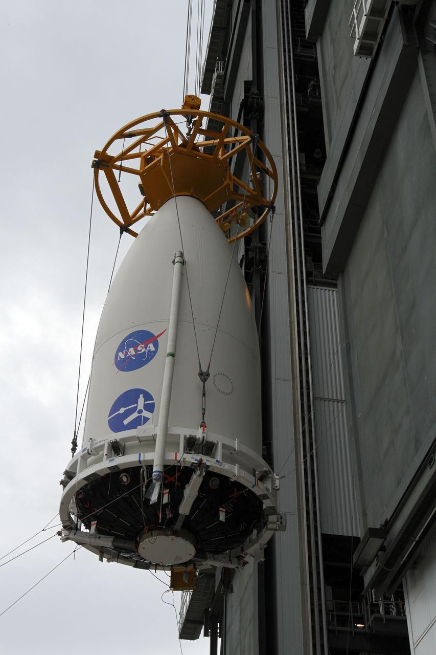 CAPE CANAVERAL, Fla. -- At Space Launch Complex 41, the Juno spacecraft, enclosed in an Atlas payload fairing, is lifted slowly and carefully up the outside of the Vertical Integration Facility to the top of the Atlas rocket already stacked inside.  The spacecraft was prepared for launch in the Astrotech Space Operations' payload processing facility in Titusville, Fla.    The fairing will protect the spacecraft from the impact of aerodynamic pressure and heating during ascent and will be jettisoned once the spacecraft is outside the Earth's atmosphere. Juno is scheduled to launch Aug. 5 aboard a United Launch Alliance Atlas V rocket from Cape Canaveral Air Force Station in Florida. The solar-powered spacecraft will orbit Jupiter's poles 33 times to find out more about the gas giant's origins, structure, atmosphere and magnetosphere and investigate the existence of a solid planetary core. For more information, visit www.nasa.gov/juno. Photo credit: NASA/Cory Huston