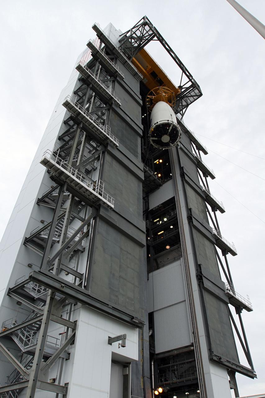CAPE CANAVERAL, Fla. -- At Space Launch Complex 41, the Juno spacecraft, enclosed in an Atlas payload fairing, nears the top of the Vertical Integration Facility where it will be positioned on top of the Atlas rocket already stacked inside.  The spacecraft was prepared for launch in the Astrotech Space Operations' payload processing facility in Titusville, Fla.    The fairing will protect the spacecraft from the impact of aerodynamic pressure and heating during ascent and will be jettisoned once the spacecraft is outside the Earth's atmosphere. Juno is scheduled to launch Aug. 5 aboard a United Launch Alliance Atlas V rocket from Cape Canaveral Air Force Station in Florida. The solar-powered spacecraft will orbit Jupiter's poles 33 times to find out more about the gas giant's origins, structure, atmosphere and magnetosphere and investigate the existence of a solid planetary core. For more information, visit www.nasa.gov/juno. Photo credit: NASA/Cory Huston