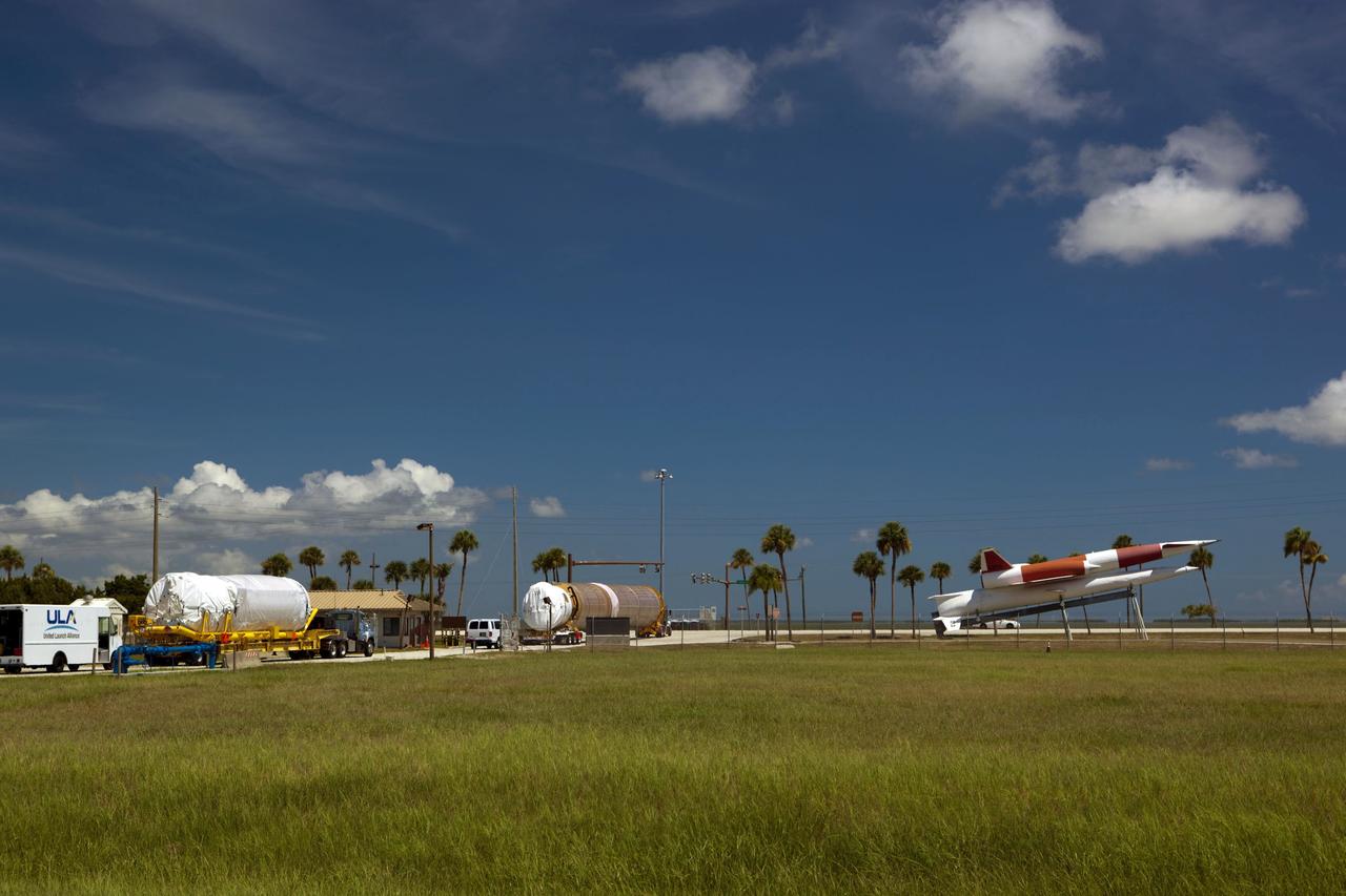 CAPE CANAVERAL, Fla. -- The Atlas V first stage (right) and Centaur upper stage to support the Mars Science Laboratory (MSL) mission pass through the main gate of Cape Canaveral Air Force Station on their way to the Atlas Spaceflight Operations Center in Florida. At the far right is a Navaho free-flying missile, on display at the station's main gate. MSL's components include a compact car-sized rover, Curiosity, which has 10 science instruments designed to search for evidence on whether Mars has had environments favorable to microbial life, including chemical ingredients for life. The unique rover will use a laser to look inside rocks and release its gasses so that the rover’s spectrometer can analyze and send the data back to Earth. Launch of MSL aboard a United Launch Alliance Atlas V rocket is scheduled for Nov. 25 from Space Launch Complex 41 on Cape Canaveral Air Force Station. For more information, visit http://www.nasa.gov/msl. Photo credit: NASA/Dimitri Gerondidakis