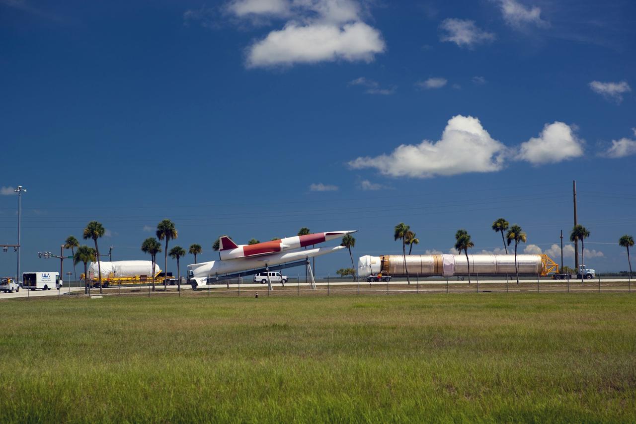 CAPE CANAVERAL, Fla. -- The Atlas V first stage (right) and Centaur upper stage to support the Mars Science Laboratory (MSL) mission enter Cape Canaveral Air Force Station on their way to the Atlas Spaceflight Operations Center in Florida. Between the stages is a Navaho free-flying missile, on display at the station's main gate. MSL's components include a compact car-sized rover, Curiosity, which has 10 science instruments designed to search for evidence on whether Mars has had environments favorable to microbial life, including chemical ingredients for life. The unique rover will use a laser to look inside rocks and release its gasses so that the rover’s spectrometer can analyze and send the data back to Earth. Launch of MSL aboard a United Launch Alliance Atlas V rocket is scheduled for Nov. 25 from Space Launch Complex 41 on Cape Canaveral Air Force Station. For more information, visit http://www.nasa.gov/msl. Photo credit: NASA/Dimitri Gerondidakis