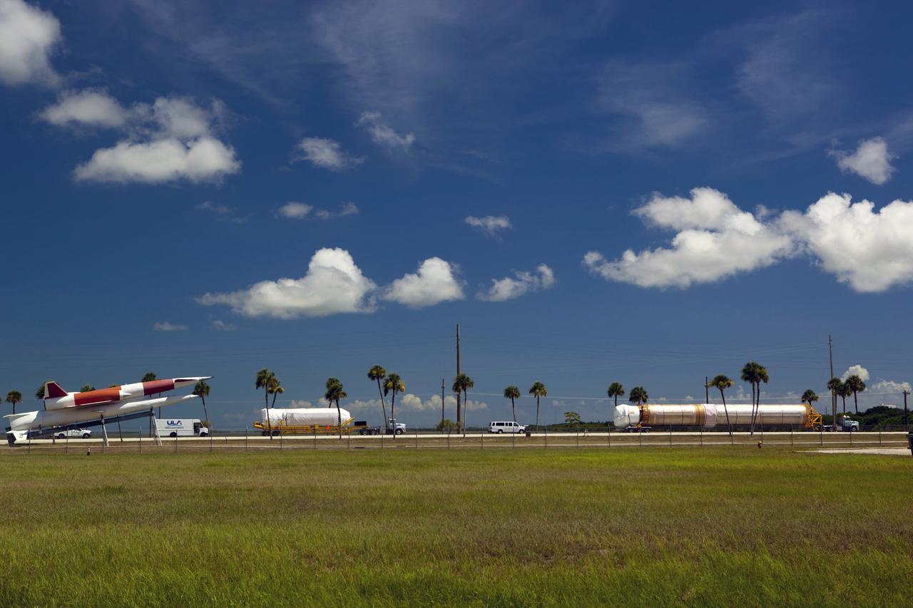 CAPE CANAVERAL, Fla. -- The Atlas V first stage (right) and Centaur upper stage to support the Mars Science Laboratory (MSL) mission make their way onto Cape Canaveral Air Force Station for delivery to the Atlas Spaceflight Operations Center in Florida. At the far left is a Navaho free-flying missile, on display at the station's main gate. MSL's components include a compact car-sized rover, Curiosity, which has 10 science instruments designed to search for evidence on whether Mars has had environments favorable to microbial life, including chemical ingredients for life. The unique rover will use a laser to look inside rocks and release its gasses so that the rover’s spectrometer can analyze and send the data back to Earth. Launch of MSL aboard a United Launch Alliance Atlas V rocket is scheduled for Nov. 25 from Space Launch Complex 41 on Cape Canaveral Air Force Station. For more information, visit http://www.nasa.gov/msl. Photo credit: NASA/Dimitri Gerondidakis