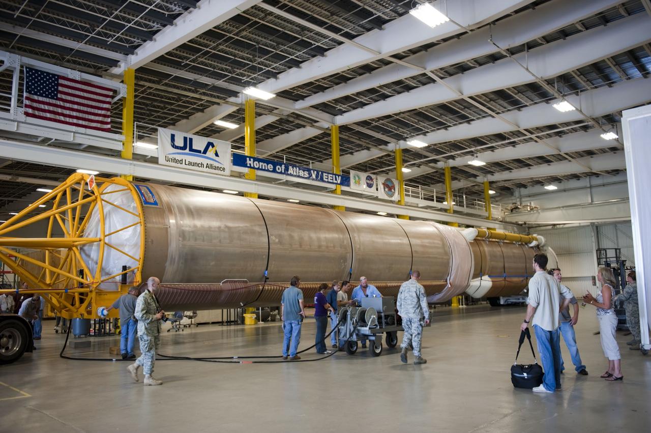 CAPE CANAVERAL, Fla. -- United Launch Alliance (ULA) workers prepare to process the first stage of the Atlas V for the Mars Science Laboratory (MSL) mission, newly arrived in the Atlas Spaceflight Operations Center on Cape Canaveral Air Force Station in Florida.    MSL's components include a compact car-sized rover, Curiosity, which has 10 science instruments designed to search for evidence on whether Mars has had environments favorable to microbial life, including chemical ingredients for life.  The unique rover will use a laser to look inside rocks and release its gasses so that the rover’s spectrometer can analyze and send the data back to Earth. Launch of MSL aboard a United Launch Alliance Atlas V rocket is scheduled for Nov. 25 from Space Launch Complex 41 on Cape Canaveral Air Force Station. For more information, visit http://www.nasa.gov/msl. Photo credit: NASA/Kim Shiflett