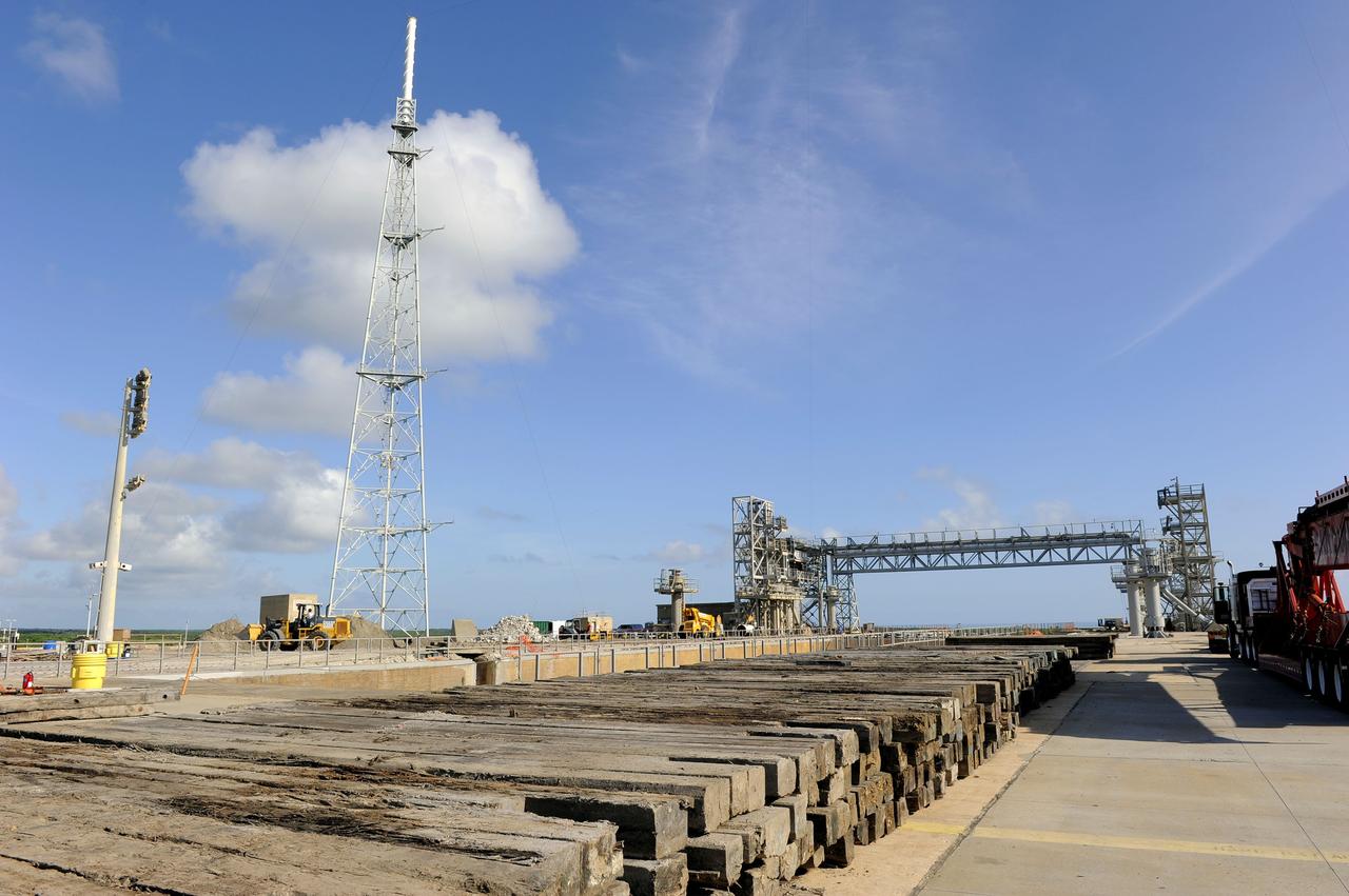 CAPE CANAVERAL, Fla. -- At NASA's Kennedy Space Center in Florida, cleanup of Launch Pad 39B gets under way. Sand, reinforcing steel and large wooden mats were placed over the pad's concrete surfaces during deconstruction to protect them from falling debris. In 2009, the structure at the pad was no longer needed for NASA's Space Shuttle Program, so it is being restructured for future use. The new design will feature a "clean pad" for rockets to come with their own launcher, making it more versatile for a number of rockets and spacecraft. The lightning protection system, consisting of three lightning towers and a wire catenary system, will remain. For information on NASA's future plans, visit http://www.nasa.gov/exploration. Photo credit: NASA/Kim Shiflett