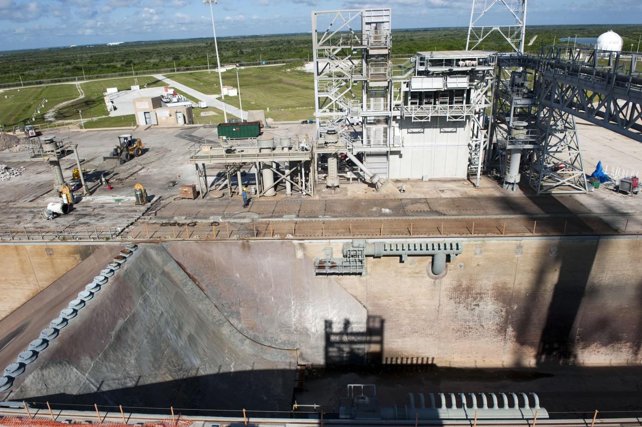 CAPE CANAVERAL, Fla. -- At NASA's Kennedy Space Center in Florida, cleanup of Launch Pad 39B is in progress beside the pad's flame trench. The trench is 450 feet long, 58 feet wide and 42 feet deep with an inner inverted V-shaped steel flame deflector. Sand, reinforcing steel and large wooden mats were placed over the pad's concrete surfaces during deconstruction to protect them from falling debris. In 2009, the structure at the pad was no longer needed for NASA's Space Shuttle Program, so it is being restructured for future use. The new design will feature a "clean pad" for rockets to come with their own launcher, making it more versatile for a number of rockets and spacecraft. The lightning protection system, consisting of three lightning towers and a wire catenary system, will remain. For information on NASA's future plans, visit http://www.nasa.gov/exploration. Photo credit: NASA/Kim Shiflett