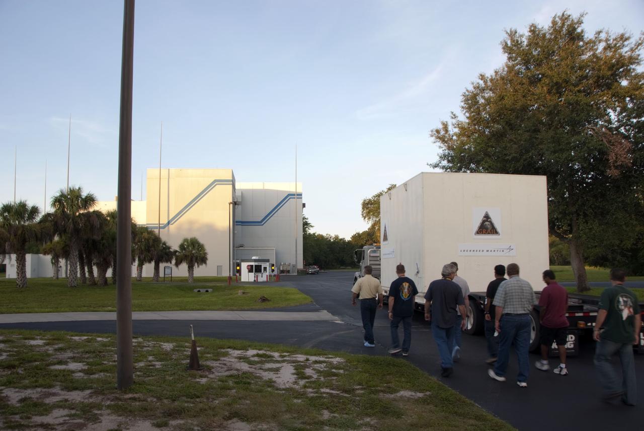 CAPE CANAVERAL, Fla. -- Lockheed Martin technicians escort the protective canister housing NASA's twin Gravity Recovery and Interior Laboratory lunar spacecraft to the Hazardous Processing Facility (HPF) at Astrotech Space Operation's payload processing facility in Titusville, Fla.  In the HPF, the spacecraft will undergo two days of fueling activities.    GRAIL will fly in tandem orbits around the moon for several months to measure its gravity field. GRAIL's primary science objectives are to determine the structure of the lunar interior, from crust to core, and to advance understanding of the thermal evolution of the moon.  Launch aboard a United Launch Alliance Delta II rocket from Space Launch Complex 17B on Cape Canaveral Air Force Station is scheduled for Sept. 8.  For more information, visit http://www.nasa.gov/grail. Photo credit: NASA/Charisse Nahser