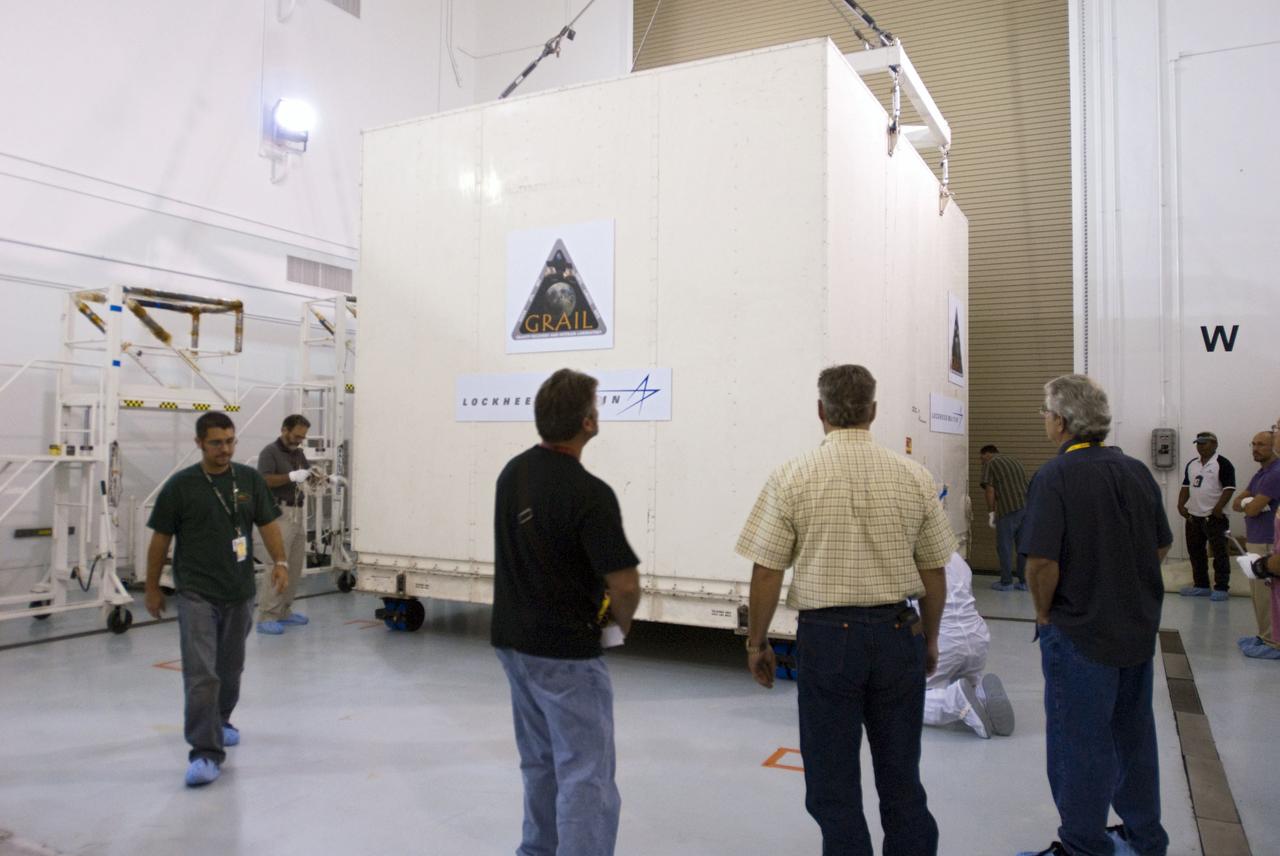 CAPE CANAVERAL, Fla. -- Lockheed Martin technicians oversee the placement of the protective canister housing NASA's twin Gravity Recovery and Interior Laboratory lunar spacecraft on the workroom floor in the Hazardous Processing Facility (HPF) at Astrotech Space Operation's payload processing facility in Titusville, Fla. In the HPF, the spacecraft will undergo two days of fueling activities. GRAIL will fly in tandem orbits around the moon for several months to measure its gravity field. GRAIL's primary science objectives are to determine the structure of the lunar interior, from crust to core, and to advance understanding of the thermal evolution of the moon. Launch aboard a United Launch Alliance Delta II rocket from Space Launch Complex 17B on Cape Canaveral Air Force Station is scheduled for Sept. 8. For more information, visit http://www.nasa.gov/grail. Photo credit: NASA/Charisse Nahser