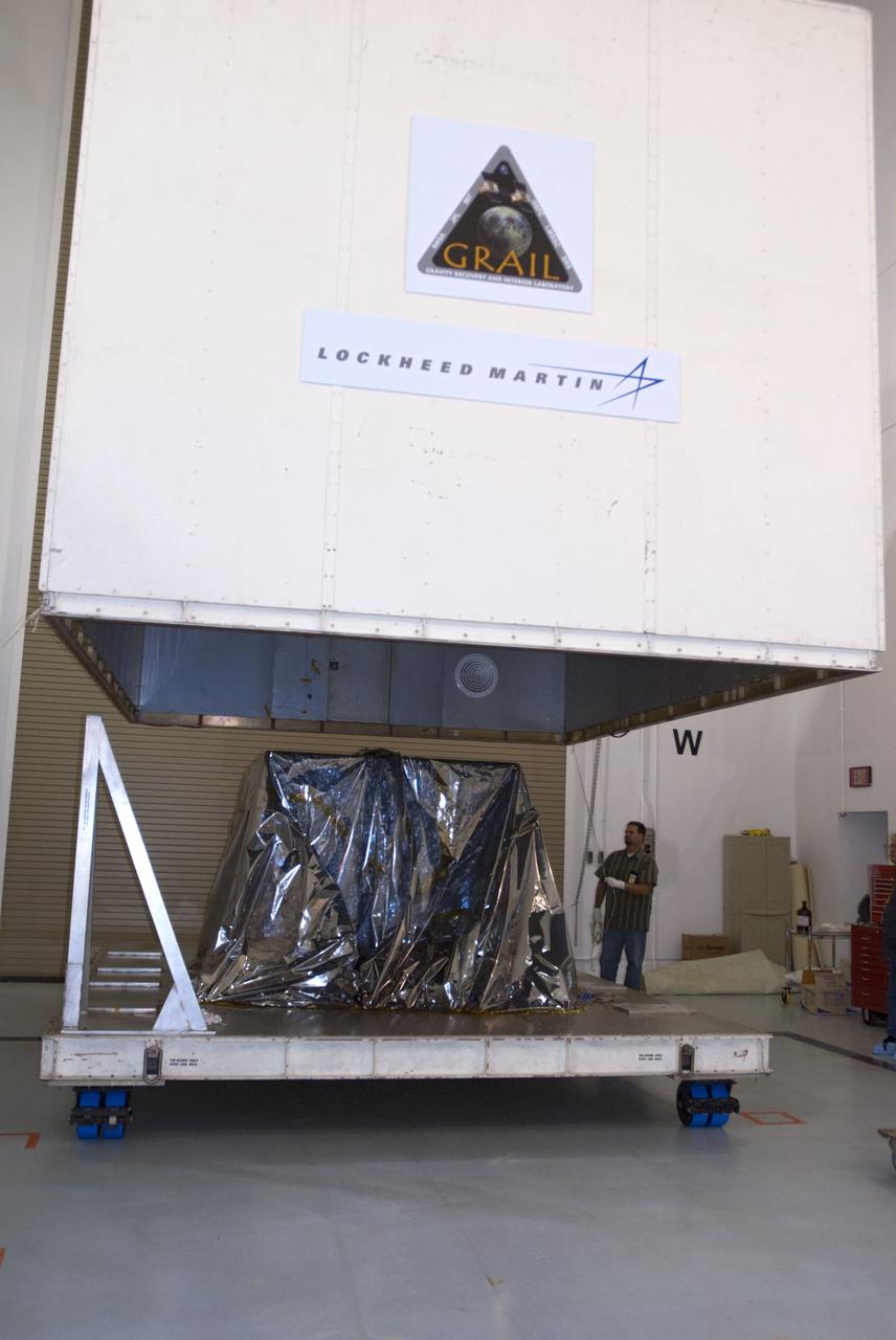 CAPE CANAVERAL, Fla. -- The protective canister housing NASA's twin Gravity Recovery and Interior Laboratory lunar spacecraft is lifted from around the mylar-covered spacecraft in the Hazardous Processing Facility (HPF) at Astrotech Space Operation's payload processing facility in Titusville, Fla. In the HPF, the spacecraft will undergo two days of fueling activities. GRAIL will fly in tandem orbits around the moon for several months to measure its gravity field. GRAIL's primary science objectives are to determine the structure of the lunar interior, from crust to core, and to advance understanding of the thermal evolution of the moon. Launch aboard a United Launch Alliance Delta II rocket from Space Launch Complex 17B on Cape Canaveral Air Force Station is scheduled for Sept. 8. For more information, visit http://www.nasa.gov/grail. Photo credit: NASA/Charisse Nahser