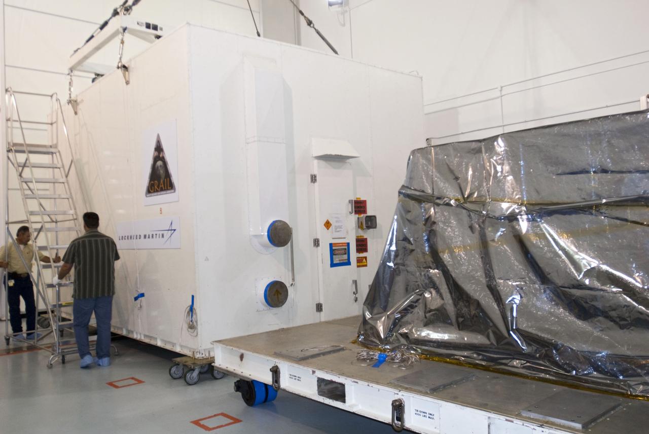 CAPE CANAVERAL, Fla. -- The protective canister housing NASA's twin Gravity Recovery and Interior Laboratory lunar spacecraft is rolled away from the mylar-covered spacecraft in the Hazardous Processing Facility (HPF) at Astrotech Space Operation's payload processing facility in Titusville, Fla.  In the HPF, the spacecraft will undergo two days of fueling activities.    GRAIL will fly in tandem orbits around the moon for several months to measure its gravity field. GRAIL's primary science objectives are to determine the structure of the lunar interior, from crust to core, and to advance understanding of the thermal evolution of the moon.  Launch aboard a United Launch Alliance Delta II rocket from Space Launch Complex 17B on Cape Canaveral Air Force Station is scheduled for Sept. 8.  For more information, visit http://www.nasa.gov/grail. Photo credit: NASA/Charisse Nahser