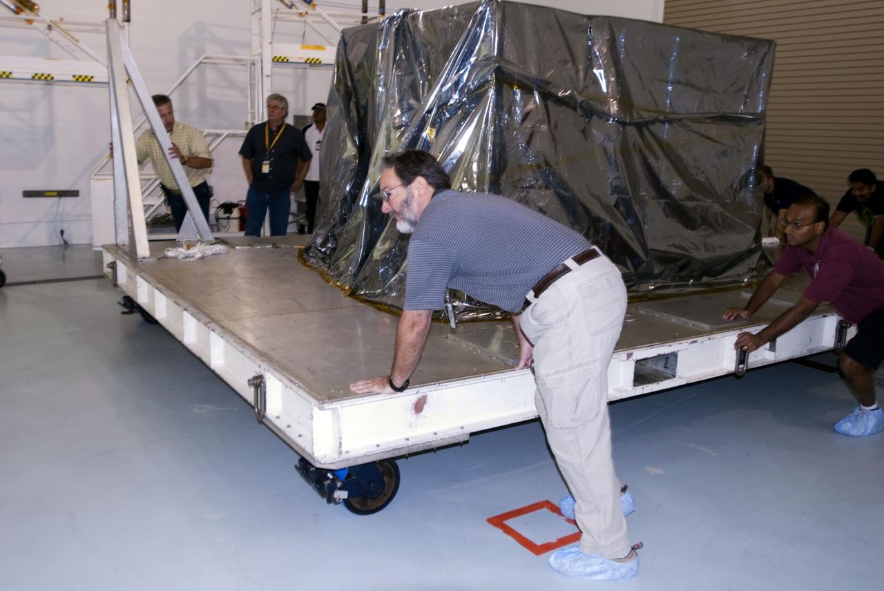CAPE CANAVERAL, Fla. -- Lockheed Martin technicians push NASA's mylar-covered twin Gravity Recovery and Interior Laboratory lunar spacecraft toward the work area of the Hazardous Processing Facility (HPF) at Astrotech Space Operation's payload processing facility in Titusville, Fla. In the HPF, the spacecraft will undergo two days of fueling activities. GRAIL will fly in tandem orbits around the moon for several months to measure its gravity field. GRAIL's primary science objectives are to determine the structure of the lunar interior, from crust to core, and to advance understanding of the thermal evolution of the moon. Launch aboard a United Launch Alliance Delta II rocket from Space Launch Complex 17B on Cape Canaveral Air Force Station is scheduled for Sept. 8. For more information, visit http://www.nasa.gov/grail. Photo credit: NASA/Charisse Nahser