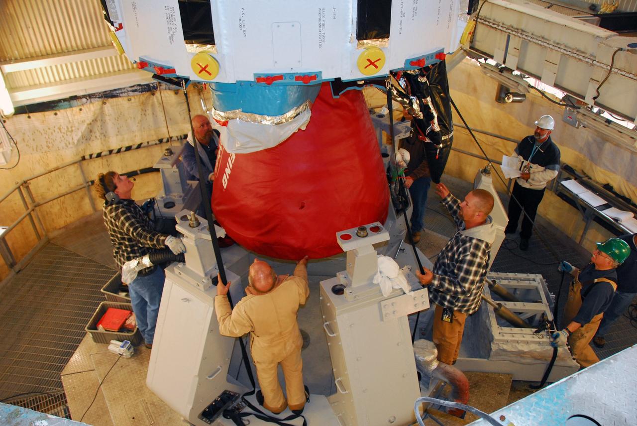 VANDENBERG AIR FORCE BASE, Calif. -- The first stage of a United Launch Alliance Delta II is lowered into place at NASA's Space Launch Complex-2 on Vandenberg Air Force Base in California. Seen here in red is the Rocketdyne engine that will help loft the rocket off the pad. The rocket will carry NASA's National Polar-orbiting Operational Environmental Satellite System Preparatory Project (NPP) satellite into space.    NPP will be positioned 512 miles above the Earth's surface and will orbit about 16 times each day to observe nearly the entire globe. The NPP mission for NASA and the National Oceanic and Atmospheric Administration (NOAA) is to measure Earth's atmospheric and sea surface temperatures, humidity sounding, land and ocean biological activity, and cloud and aerosol properties. For more information, visit www.nasa.gov/NPP. Photo credit: NASA/VAFB, Mark Mackley