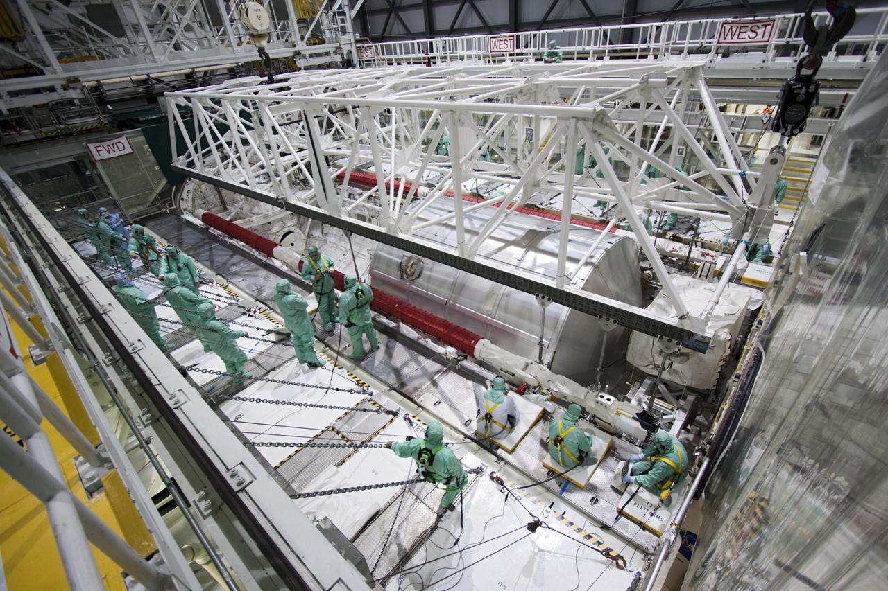 CAPE CANAVERAL, Fla. -- In Orbiter Processing Facility-2 (OPF-2) at NASA’s Kennedy Space Center in Florida, technicians help position a special payload removal device above Atlantis’ cargo bay in preparation to remove the Raffaello multi-purpose logistics module. Raffaello will then be readied for transport to the Space Station Processing Facility where its contents will be unloaded. Atlantis completed NASA’s final space shuttle mission, STS-135, after landing at the center’s Shuttle Landing Facility, July 21, 2011, at 5:57 a.m. EDT. Following removal of all payloads in Atlantis’ cargo bay, workers will begin to prepare the spacecraft for eventual permanent display at the Kennedy Space Center Visitor Complex. Photo credit: Jim Grossman