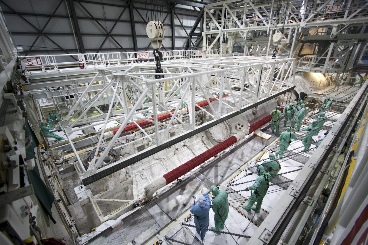 CAPE CANAVERAL, Fla. -- In Orbiter Processing Facility-2 (OPF-2) at NASA’s Kennedy Space Center in Florida, technicians monitor the progress as a special payload removal device begins to lift the Raffaello multi-purpose logistics module from Atlantis’ cargo bay. Raffaello will then be readied for transport to the Space Station Processing Facility where its contents will be unloaded. Atlantis completed NASA’s final space shuttle mission, STS-135, after landing at the center’s Shuttle Landing Facility, July 21, 2011, at 5:57 a.m. EDT. Following removal of all payloads in Atlantis’ cargo bay, workers will begin to prepare the spacecraft for eventual permanent display at the Kennedy Space Center Visitor Complex. Photo credit: Jim Grossman