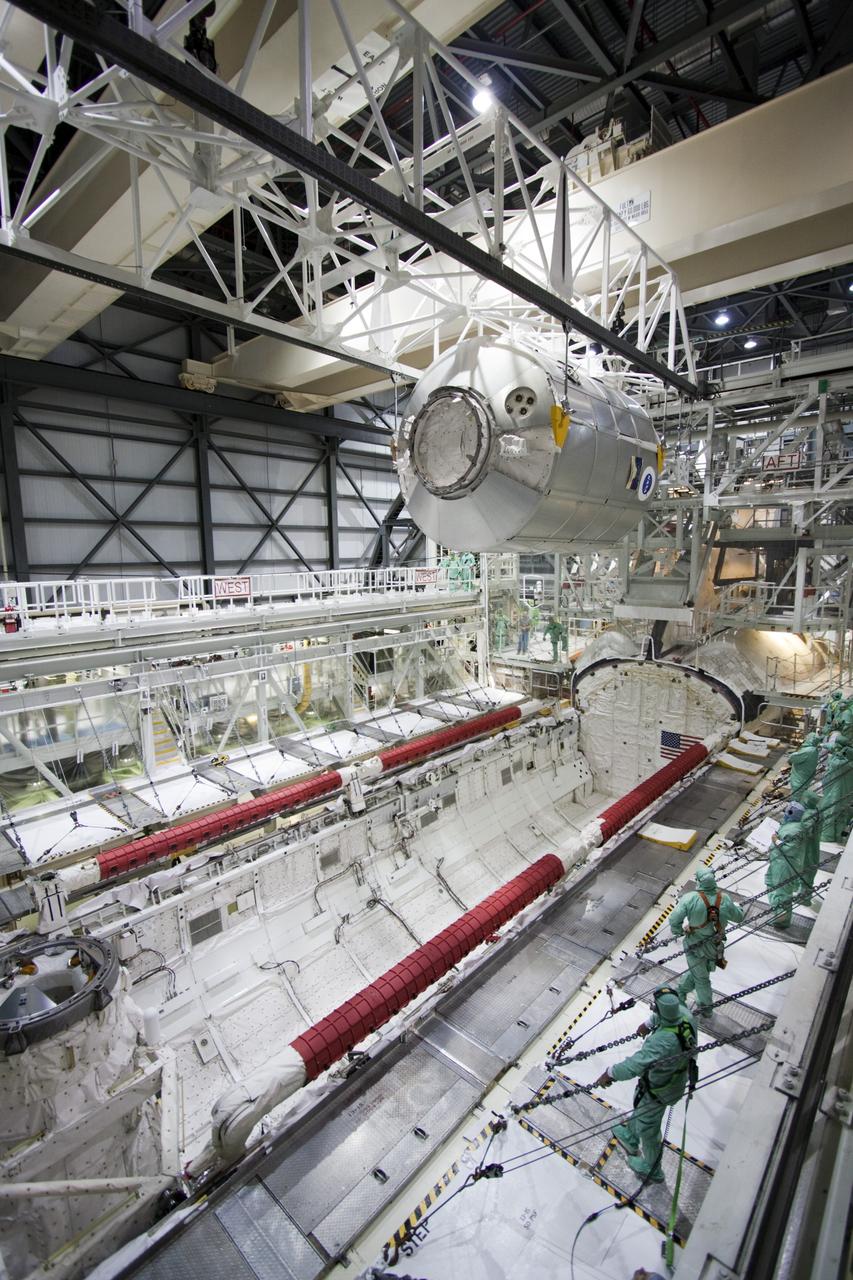 CAPE CANAVERAL, Fla. -- In Orbiter Processing Facility-2 (OPF-2) at NASA’s Kennedy Space Center in Florida, technicians monitor the progress as a special payload removal device lifts the Raffaello multi-purpose logistics module high above Atlantis’ cargo bay. Raffaello will then be readied for transport to the Space Station Processing Facility where its contents will be unloaded. Atlantis completed NASA’s final space shuttle mission, STS-135, after landing at the center’s Shuttle Landing Facility, July 21, 2011, at 5:57 a.m. EDT. Following removal of all payloads in Atlantis’ cargo bay, workers will begin to prepare the spacecraft for eventual permanent display at the Kennedy Space Center Visitor Complex. Photo credit: Jim Grossman