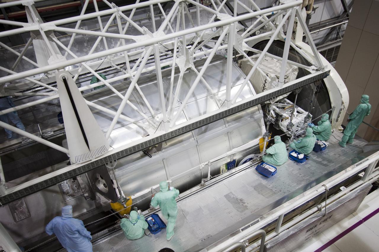 CAPE CANAVERAL, Fla. -- In Orbiter Processing Facility-2 (OPF-2) at NASA’s Kennedy Space Center in Florida, technicians monitor the progress as a special payload removal device is used to lower the Raffaello multi-purpose logistics module into the payload canister. Raffaello will then be readied for transport to the Space Station Processing Facility where its contents will be unloaded. Atlantis completed NASA’s final space shuttle mission, STS-135, after landing at the center’s Shuttle Landing Facility, July 21, 2011, at 5:57 a.m. EDT. Following removal of all payloads in Atlantis’ cargo bay, workers will begin to prepare the spacecraft for eventual permanent display at the Kennedy Space Center Visitor Complex. Photo credit: Jim Grossman