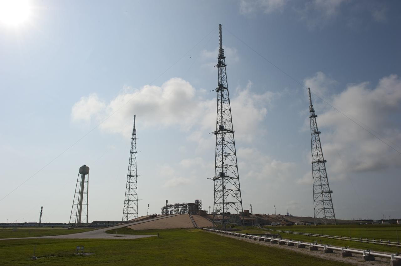 CAPE CANAVERAL, Fla. -- At NASA's Kennedy Space Center in Florida, the lightning protection system, consisting of three 600-foot-tall lightning towers, remains at Launch Pad 39B after the pad's deconstruction. Each tower is 500 feet tall and topped off with an additional 100-foot fiberglass mast which supports a wire catenary system. In 2009, the structure at the pad was no longer needed for NASA's Space Shuttle Program, so it is being restructured for future use. The new design will feature a "clean pad" for rockets to come with their own launcher, making it more versatile for a number of vehicles. For information on NASA's future plans, visit http://www.nasa.gov/exploration. Photo credit: NASA/Kim Shiflett