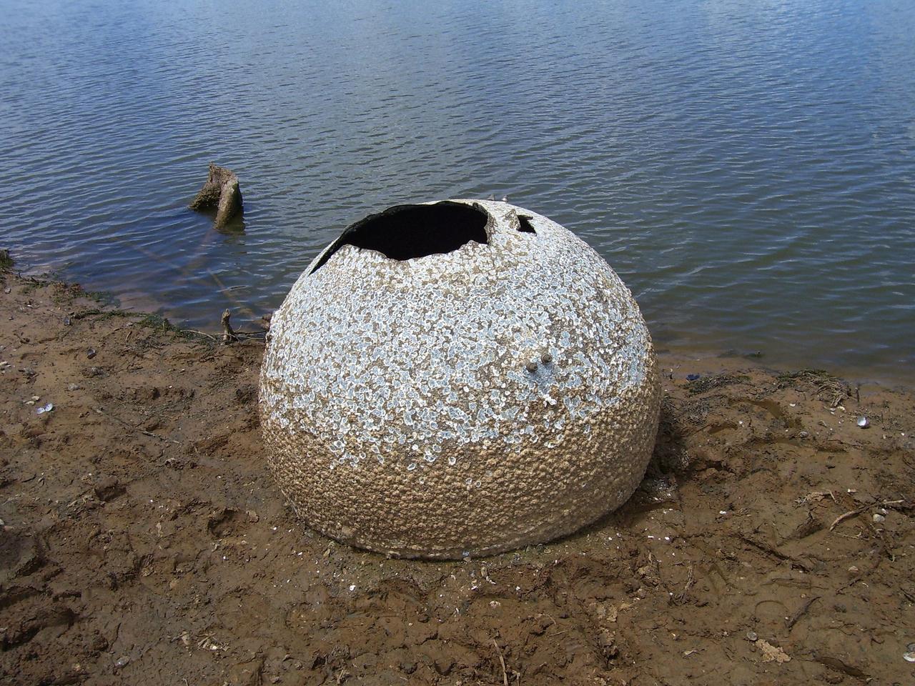 NACOGDOCHES, Texas -- A round 40-inch aluminum storage tank from space shuttle Columbia's Power Reactant and Storage Distribution System rests on the edge of Lake Nacogdoches in Texas. Lower lake water levels due to a local drought allowed the debris to become exposed. Columbia was destroyed during re-entry at the conclusion of the STS-107 mission in 2003.  Approximately 38 to 40 percent of Columbia was recovered following the accident in a half-million-acre search area which extended from eastern Texas and to western Louisiana. This tank is one of 18 cryogenic liquid storage tanks that flew aboard Columbia.  The tank is not hazardous to people or the environment and will be transported to NASA's Kennedy Space Center for storage inside the Vehicle Assembly Building with the rest of the recovered Columbia debris.    For information on STS-107 and the Columbia accident, visit http://www.nasa.gov/columbia/home/index.html. Photo credit: Nacogdoches Police Dept.