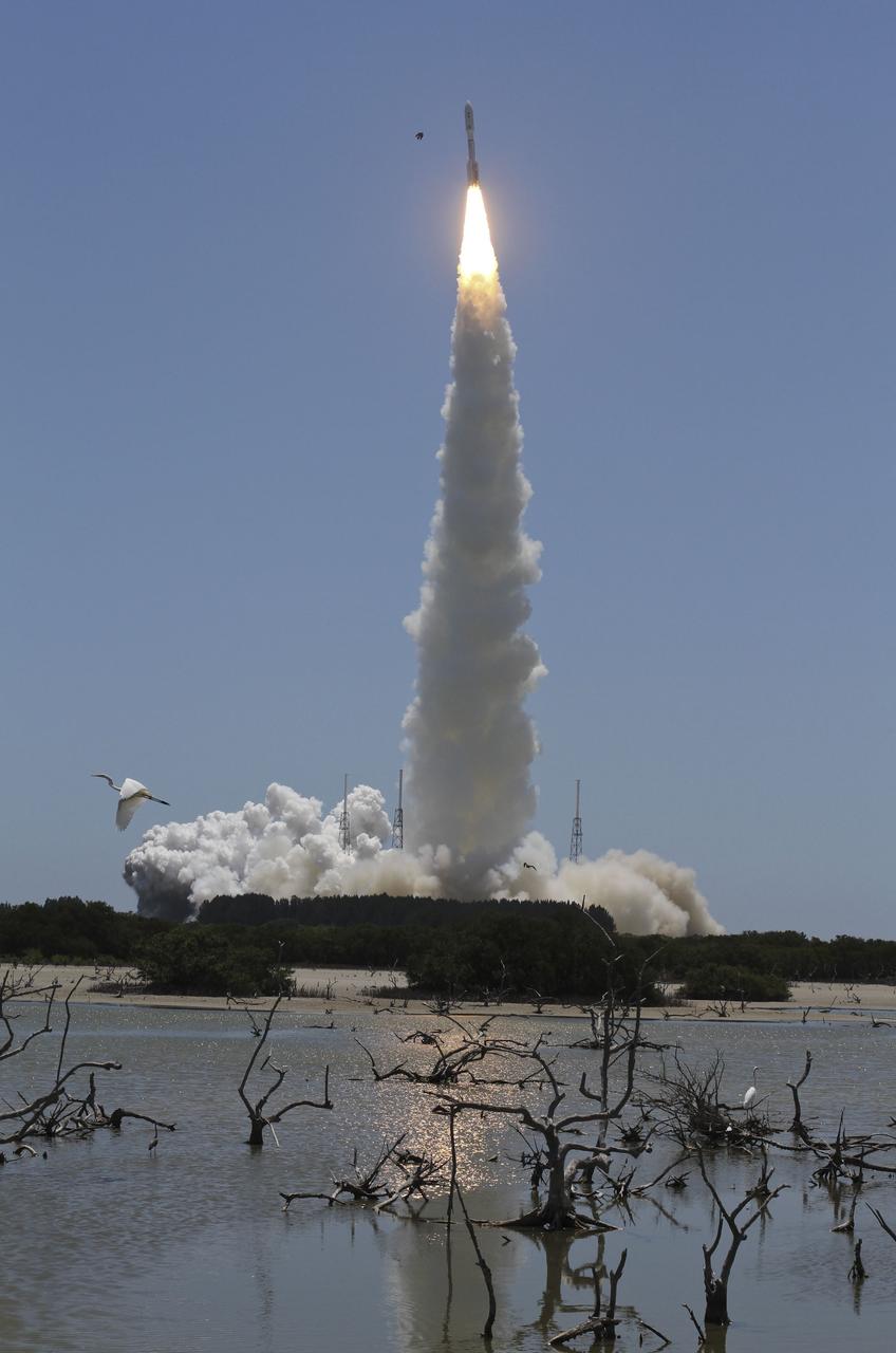 CAPE CANAVERAL, Fla. -- Reflected in water surrounding Space Launch Complex 41 on Cape Canaveral Air Force Station in Florida, fire lights up a crystal-clear blue sky as a United Launch Alliance Atlas V rocket lofts NASA's Juno planetary probe into space.           Liftoff was at 12:25 p.m. EDT Aug. 5. The solar-powered spacecraft will orbit Jupiter's poles 33 times to find out more about the gas giant's origins, structure, atmosphere and magnetosphere and investigate the existence of a solid planetary core. For more information, visit www.nasa.gov/juno. Photo credit: Courtesy Scott Andrews