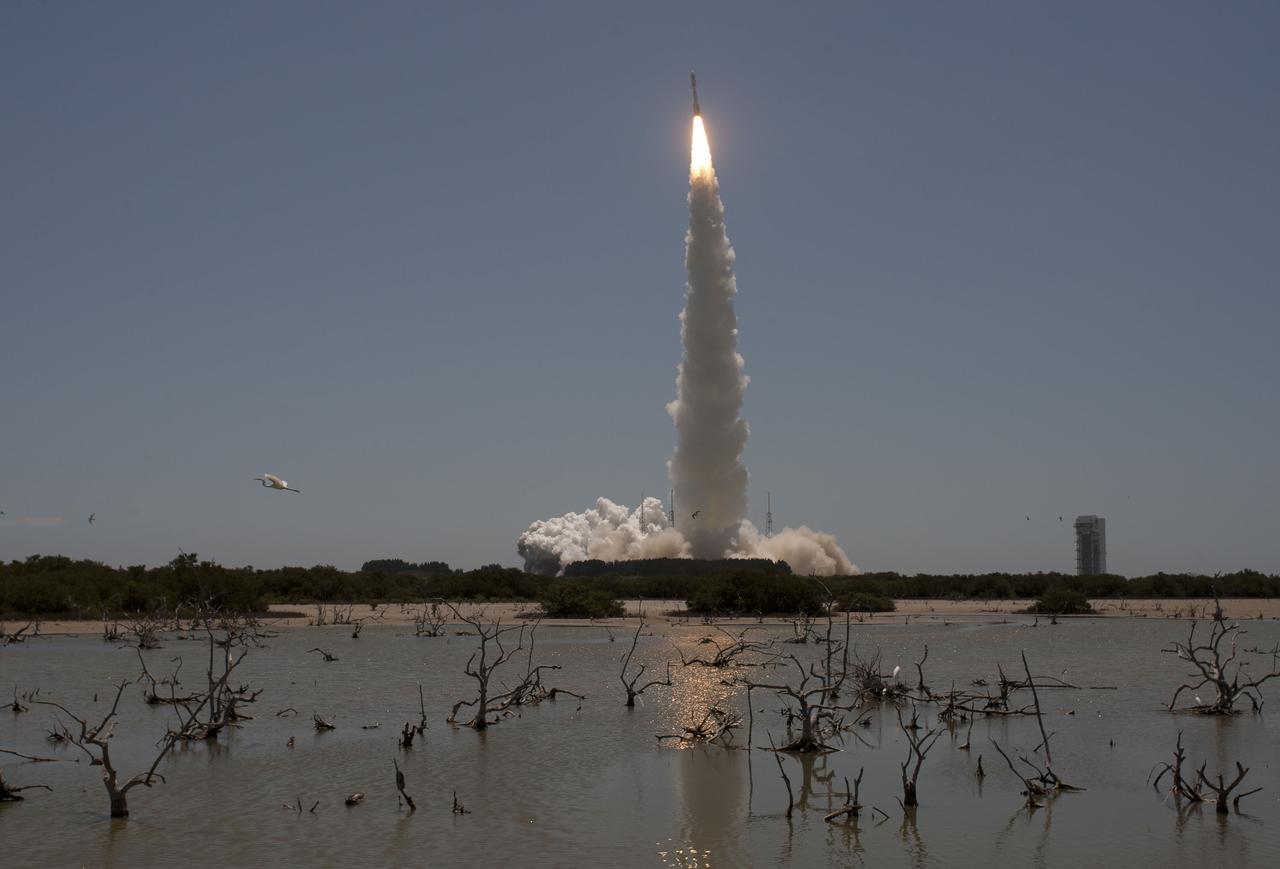 CAPE CANAVERAL, Fla. -- Reflected in water surrounding Space Launch Complex 41 on Cape Canaveral Air Force Station in Florida, fire lights up the sky as a United Launch Alliance Atlas V rocket lofts NASA's Juno planetary probe into space.         Liftoff was at 12:25 p.m. EDT Aug. 5. The solar-powered spacecraft will orbit Jupiter's poles 33 times to find out more about the gas giant's origins, structure, atmosphere and magnetosphere and investigate the existence of a solid planetary core. For more information, visit www.nasa.gov/juno. Photo credit: Courtesy Scott Andrews